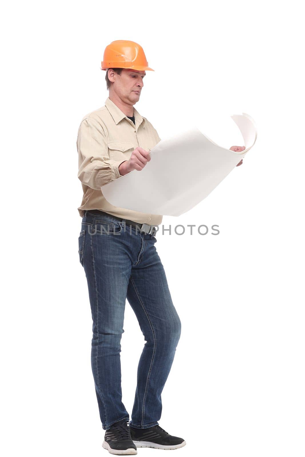 side view full length portrait of serious businessman in orange hardhat with blueprint looking forward. Isolated on white background