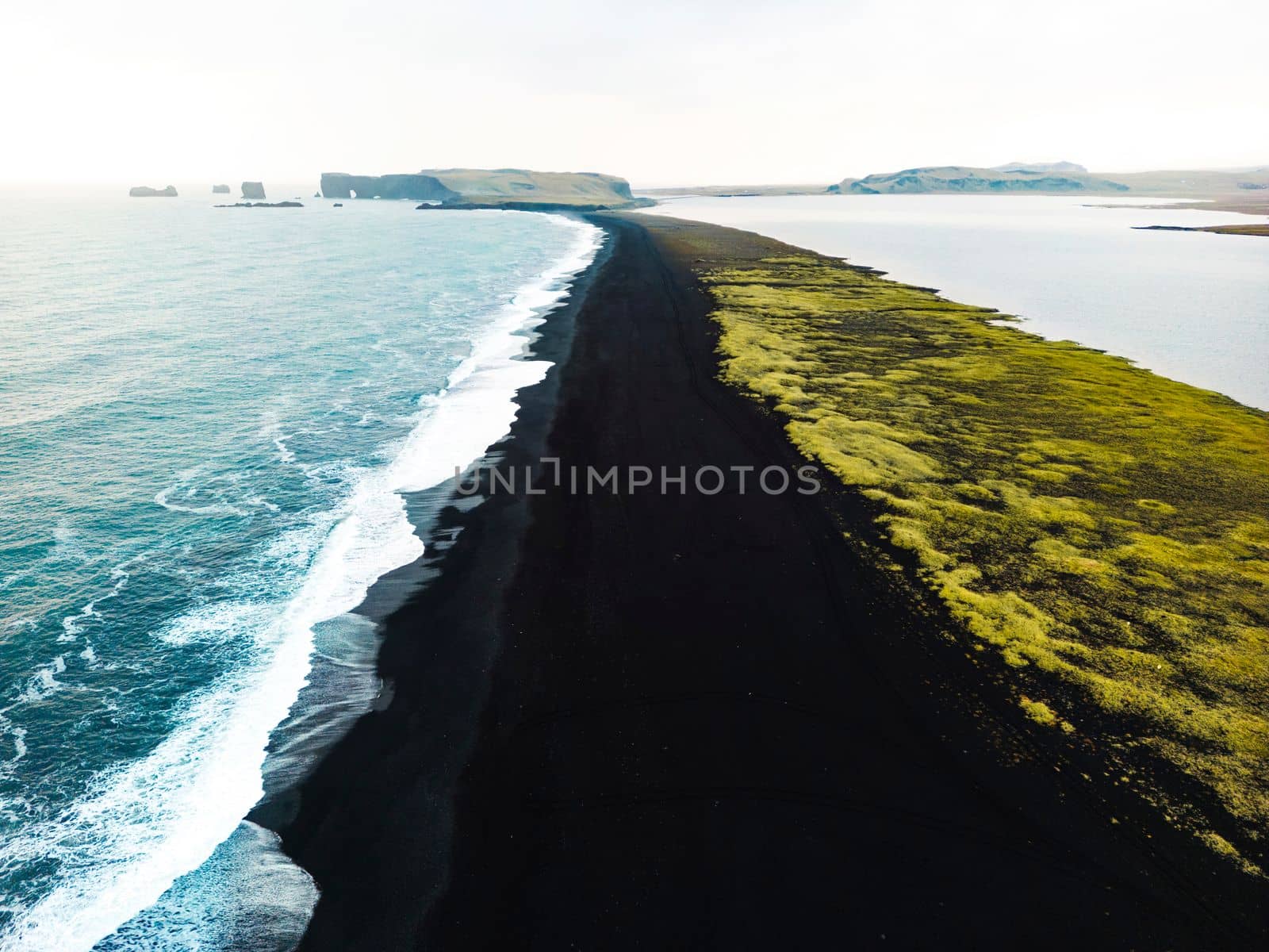 Volcanic Black Sand Beach with a view of Reynisdrangar. Waves crashing on the black sand beach. Vik, Iceland. High quality photo