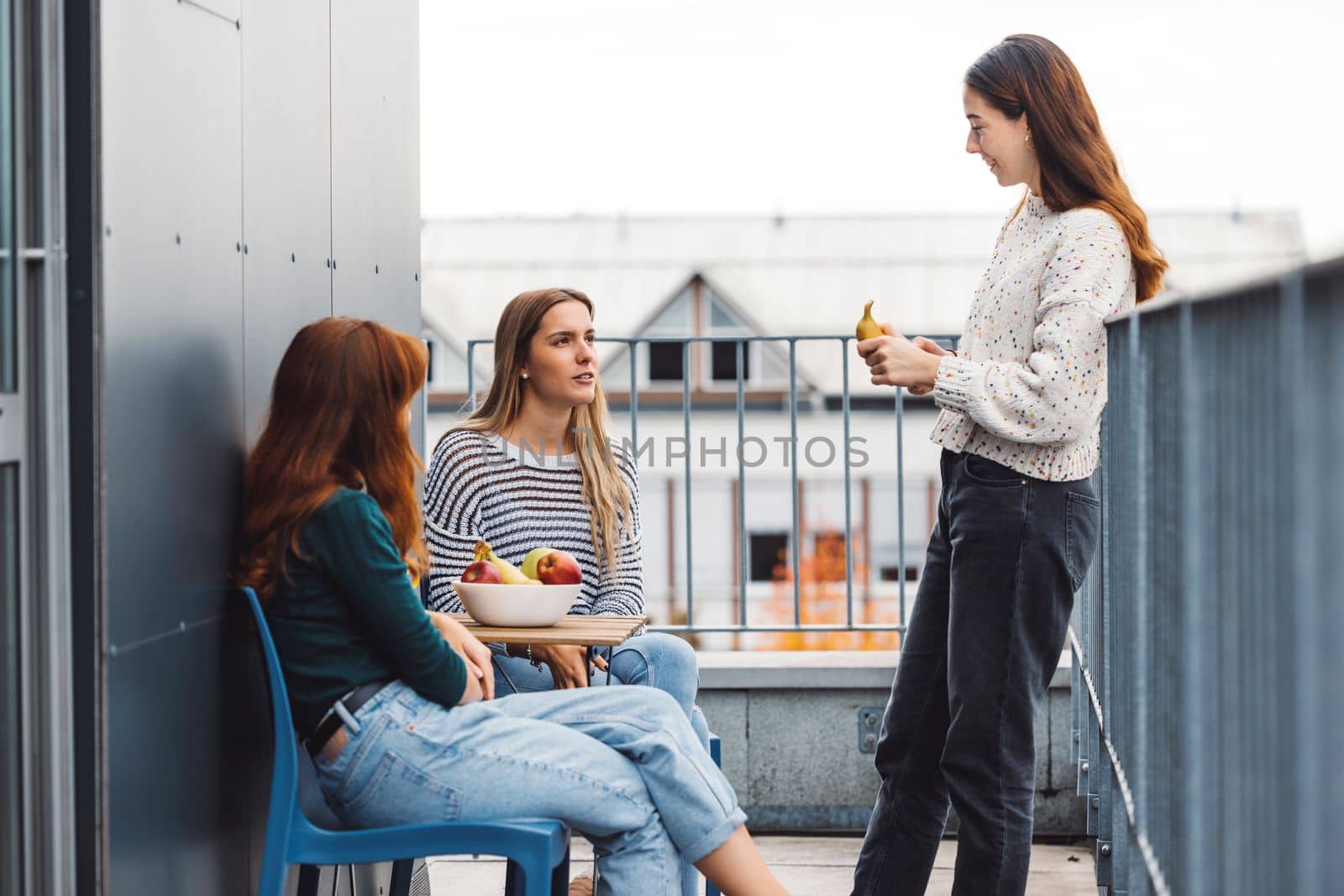 Group of friends gossiping over some hot news on their dorm room balcony by VisualProductions