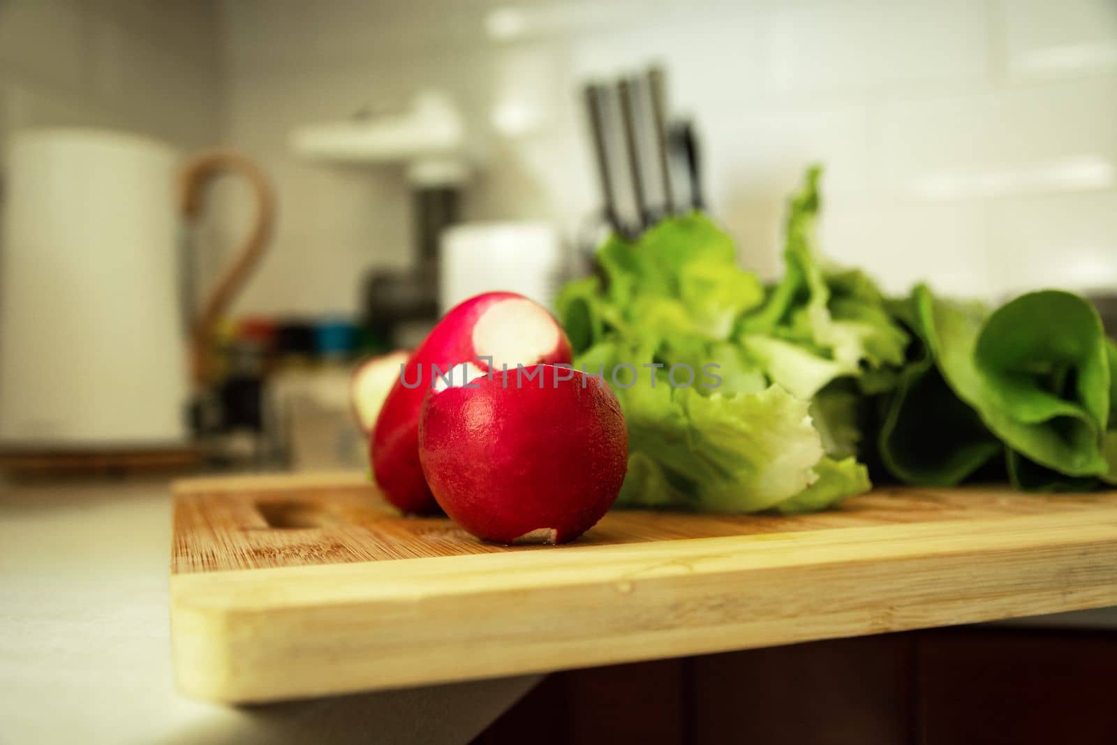 Radish and lettuce lying on a wooden chopping board