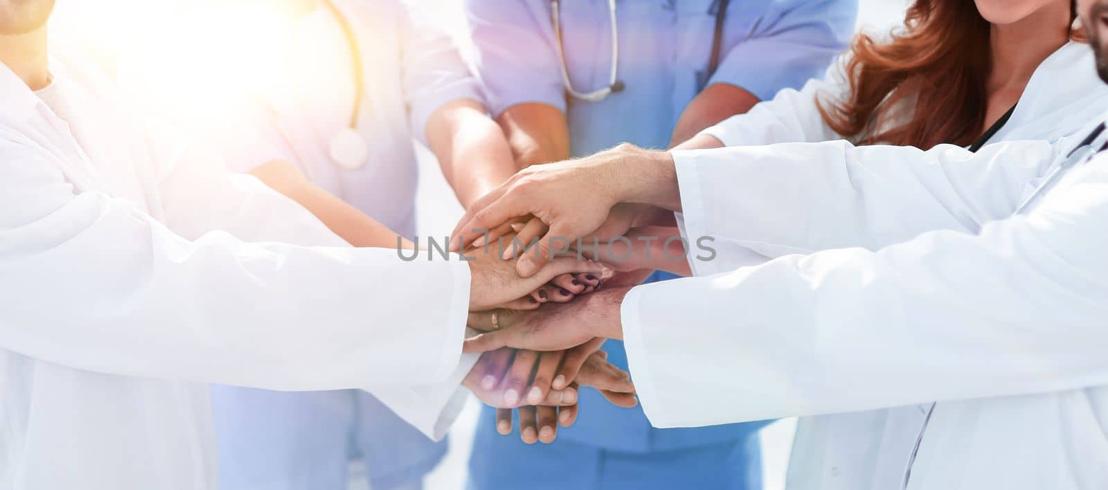 Doctors and nurses stacking hands. concept of mutual aid. by asdf