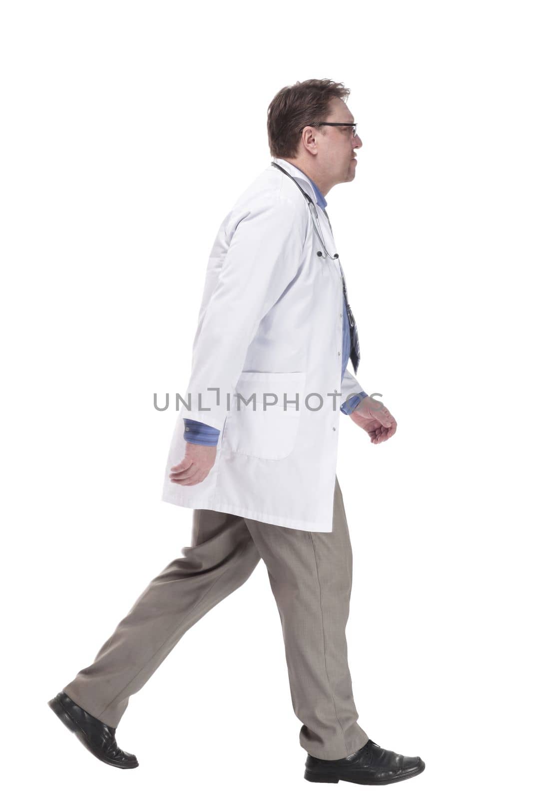 in full growth. serious doctor in a white coat striding forward.isolated on a white background.