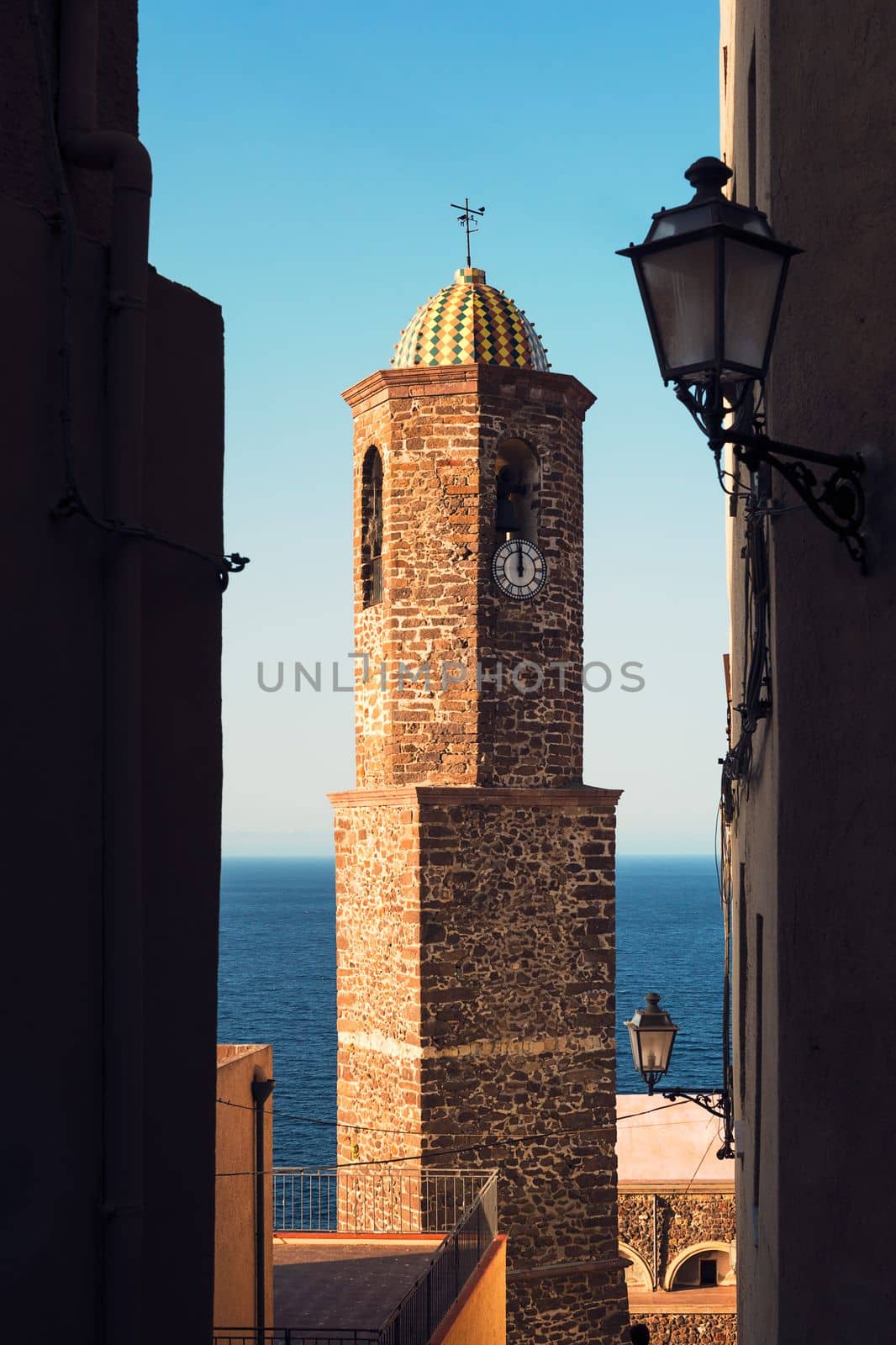 bell tower of the Castelsardo church in Sardinia, Italy, seen from the narrow streets of the citadel