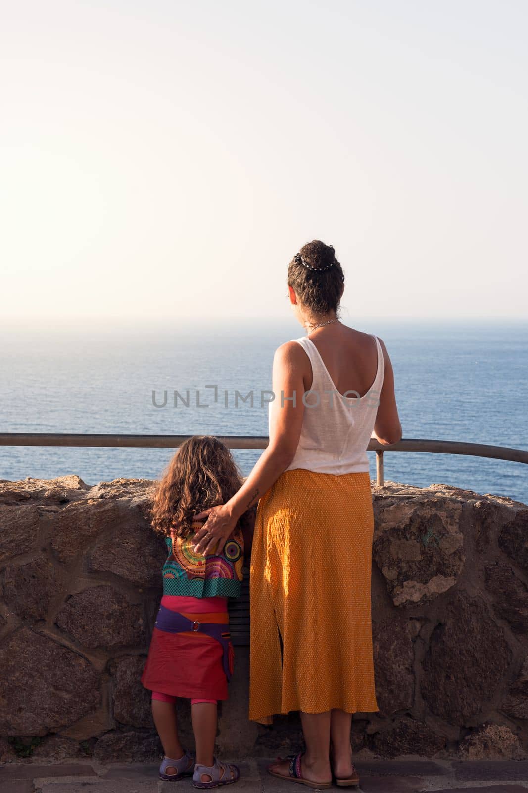 mother and daughter looking at the horizon by raulmelldo