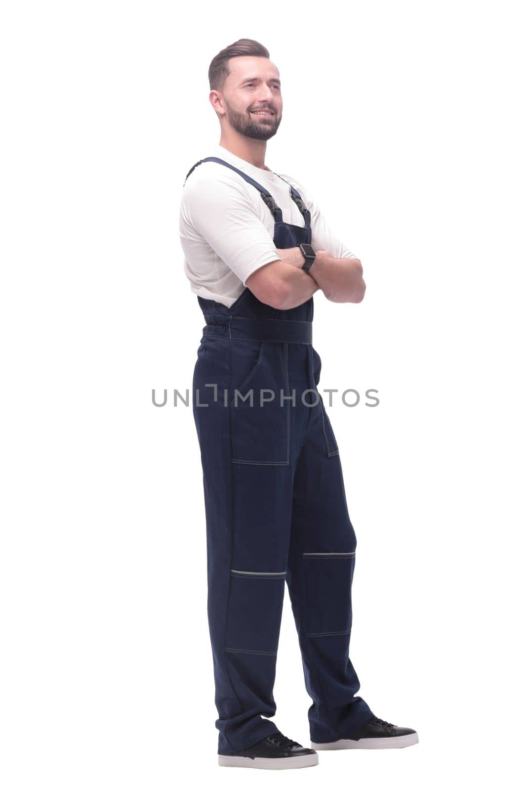 side view. smiling man in overalls looking forward to copy space. isolated on white background