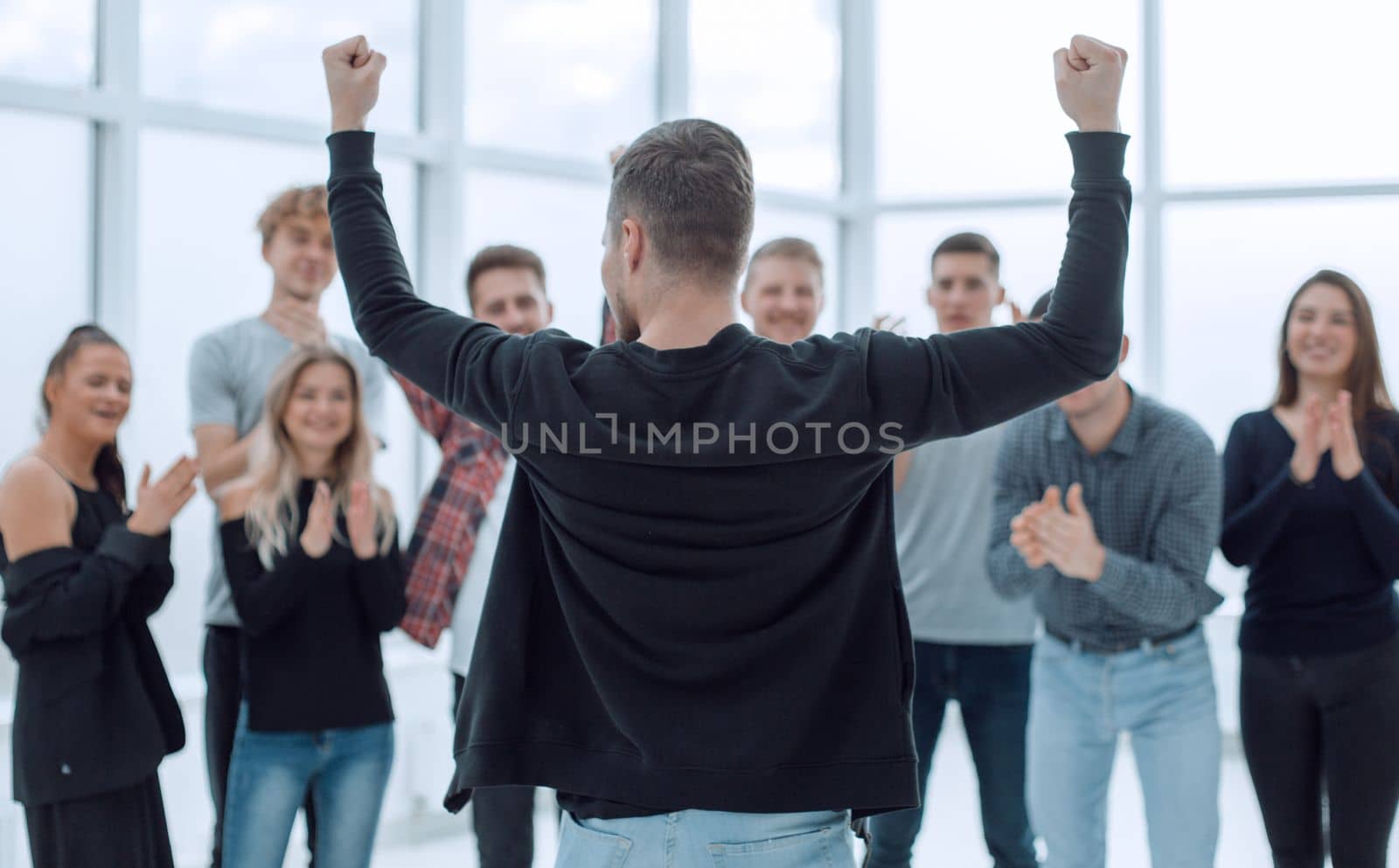 young entrepreneur standing in front of the applauding business team. the concept of success