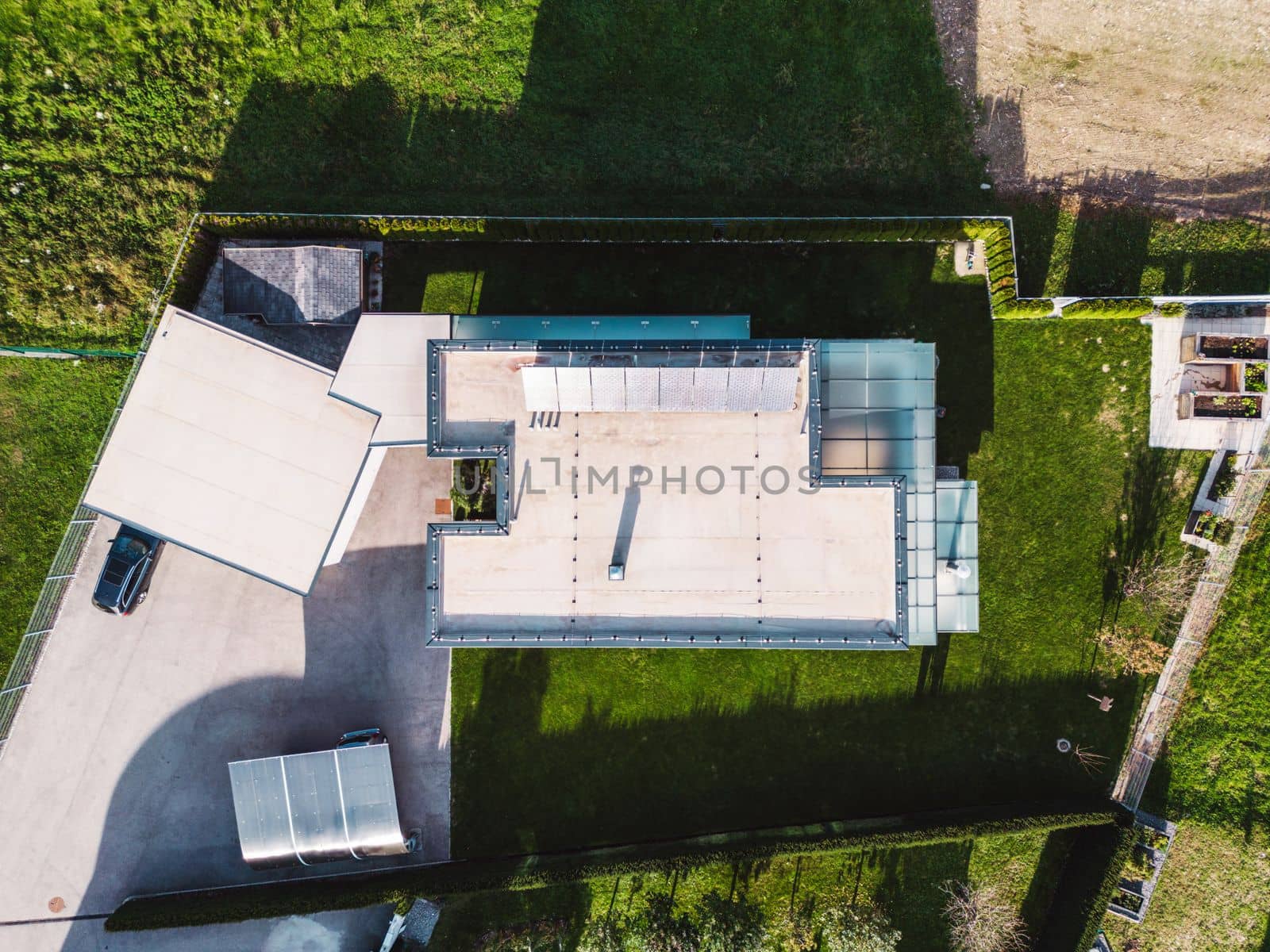 Aerial view of a modern house with solar panels on the roof top. Modern architecture, suburban home, country side living, luxury lifestyle. Renewable energy, solar panels.
