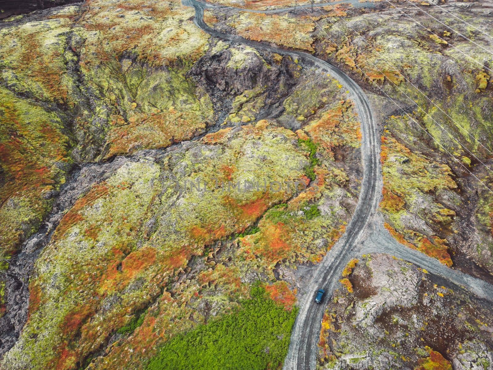 Icelandic highlands, F roads, river crossing. Remote dirt road somewhere in Iceland mainland, surrounded by vibrant green bushes and volcanic lands. A car driving alone on the gravel road.