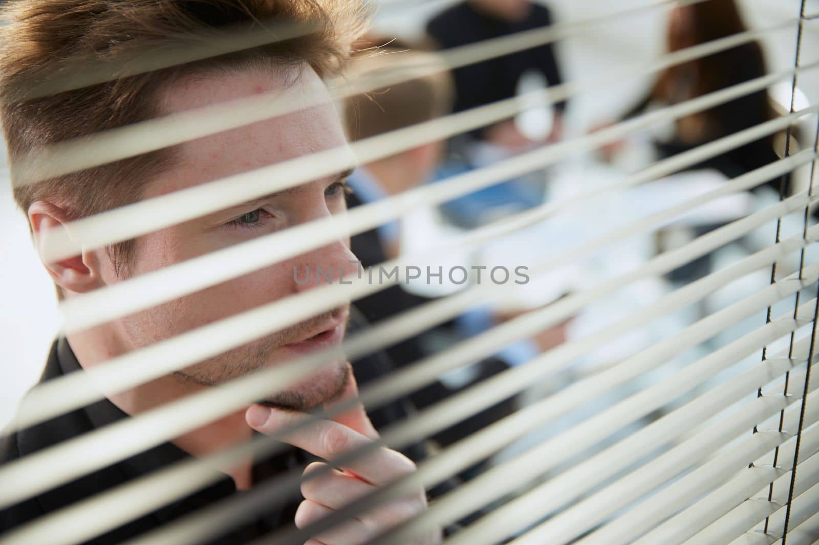 close up. young businessman looking through an office window. business concept.