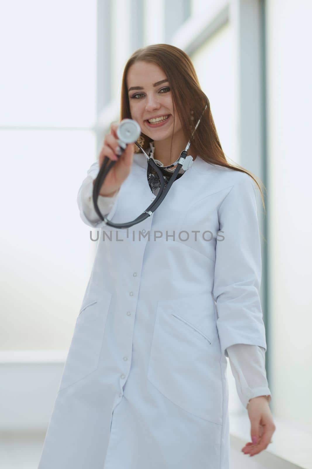 smiling female doctor with a stethoscope standing in the lobby of the hospital. photo with a copy-space.