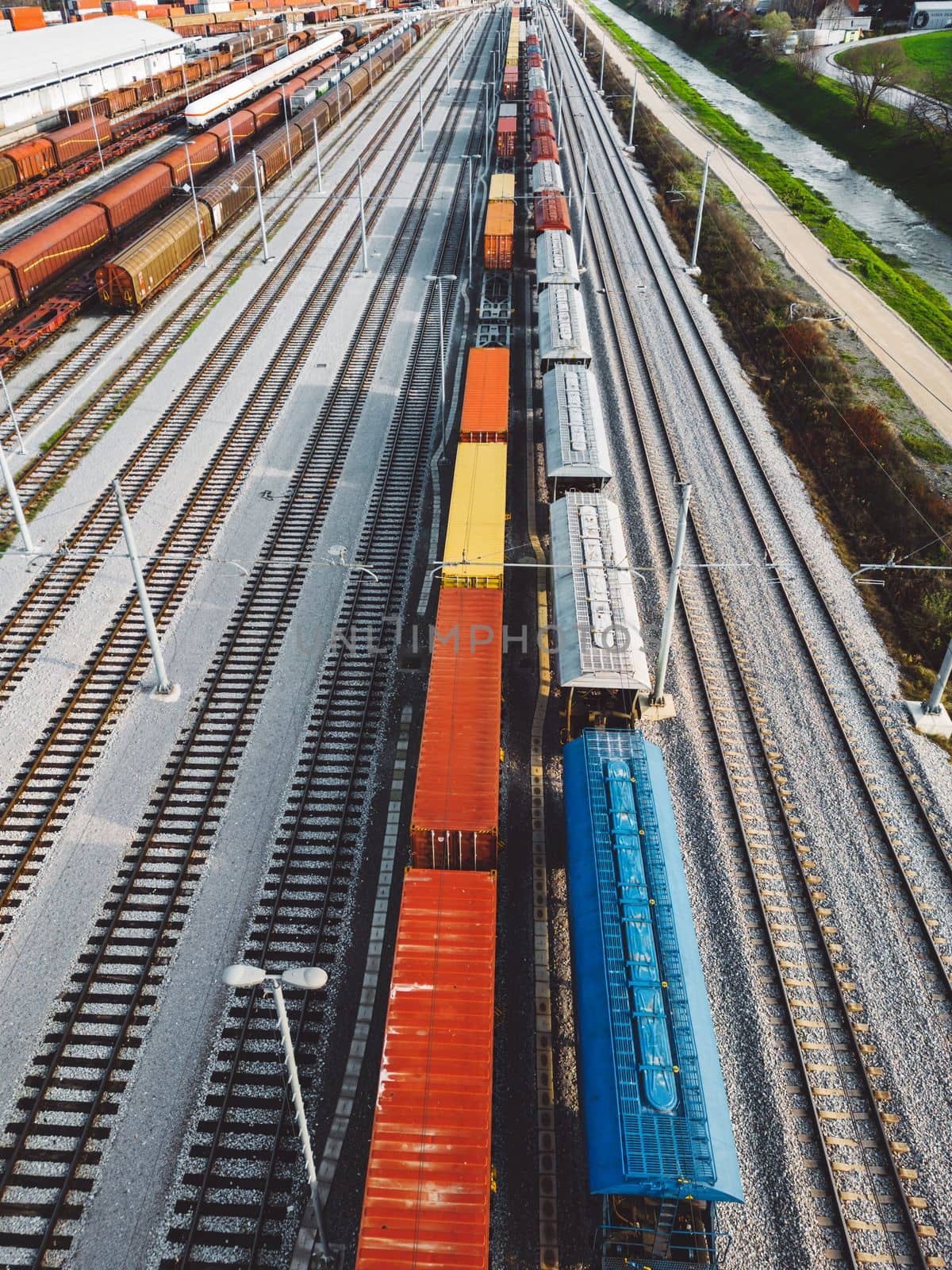 Cargo trains close-up. Aerial view of colorful freight trains on the railway station. Wagons with goods on railroad. Heavy industry. Industrial conceptual scene with trains. Top view from flying drone. High quality photo