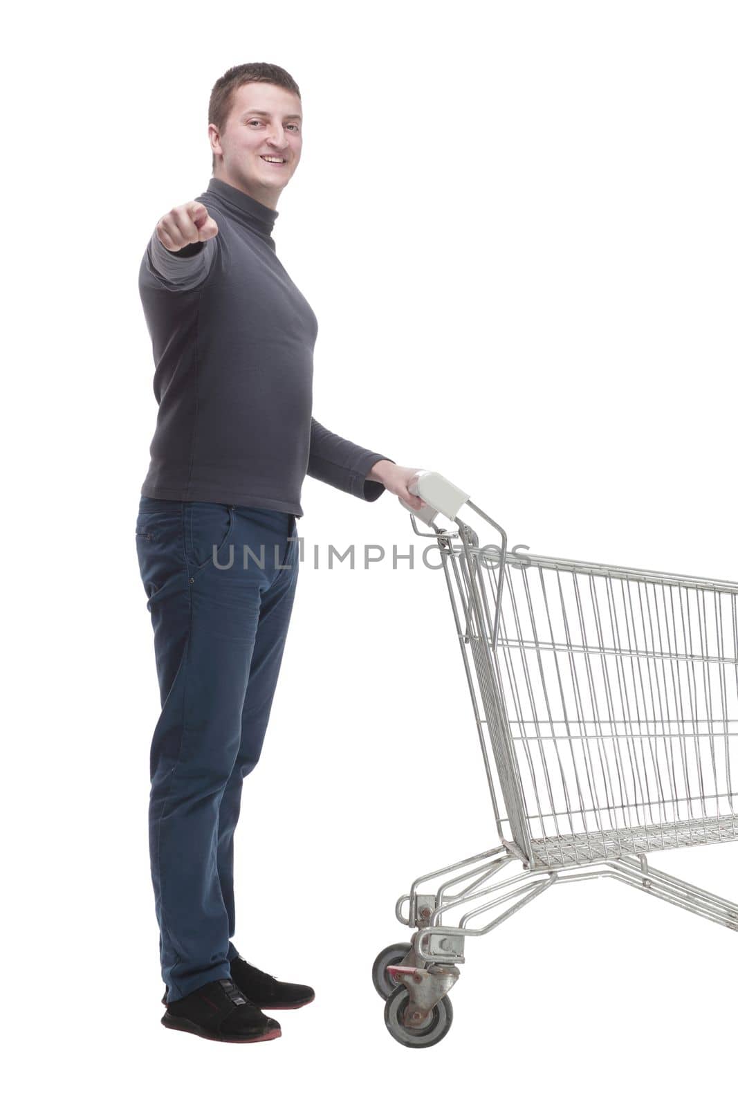 in full growth. casual young man with shopping cart. isolated on a white background.