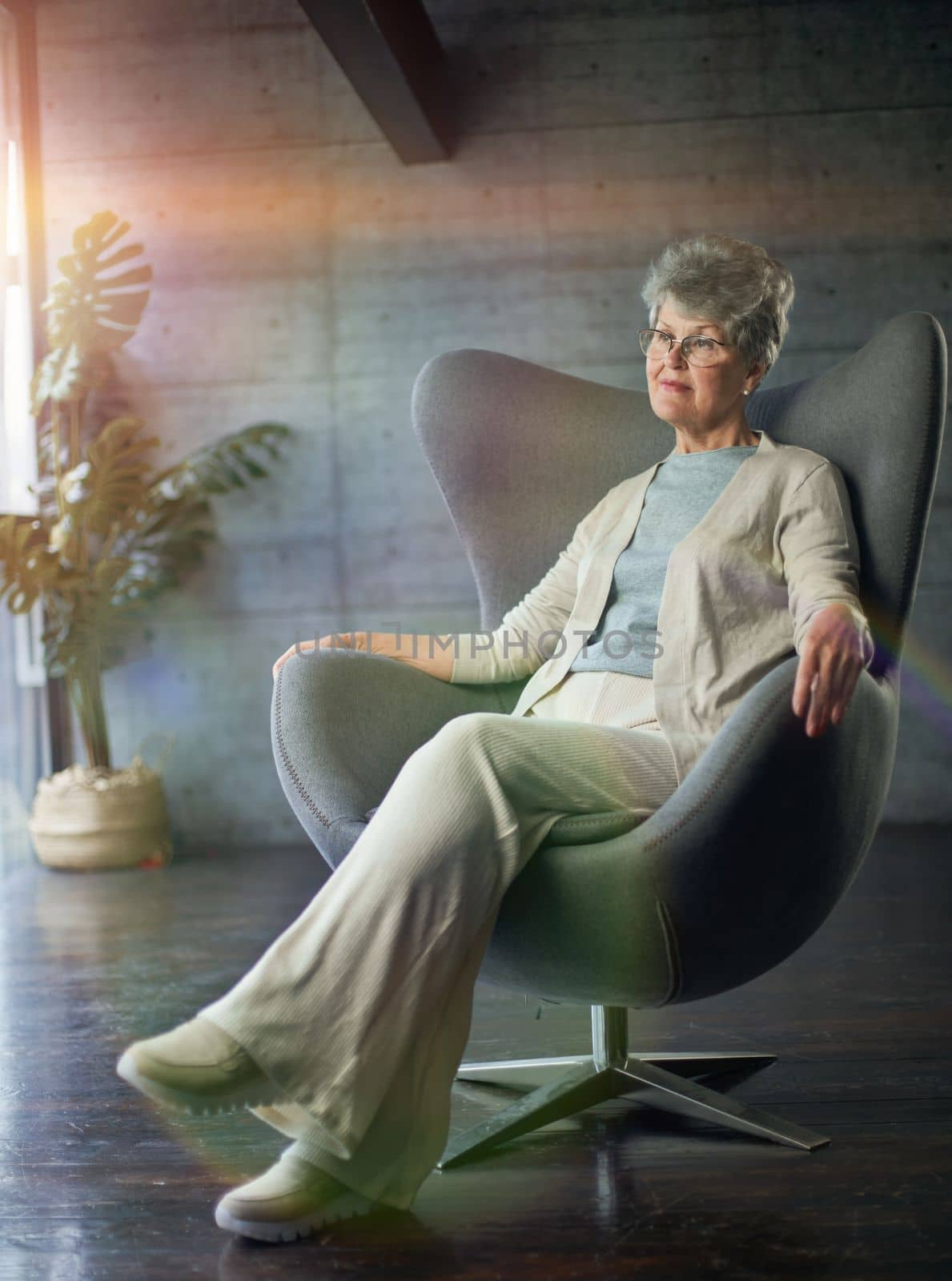 attractive middle aged smiling woman model sitting in chair looking at camera at office