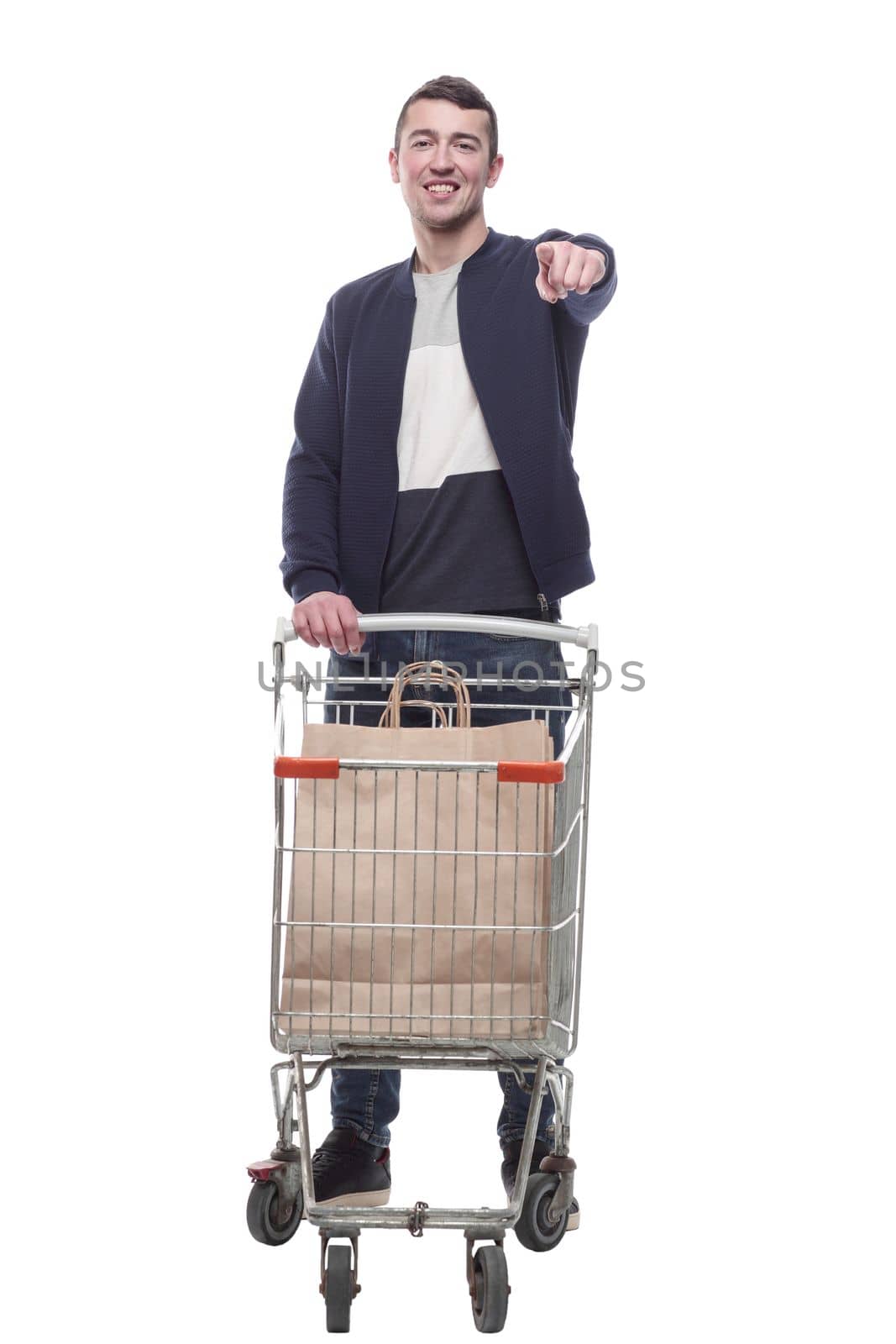 smiling young man with a shopping cart . isolated on a white background.