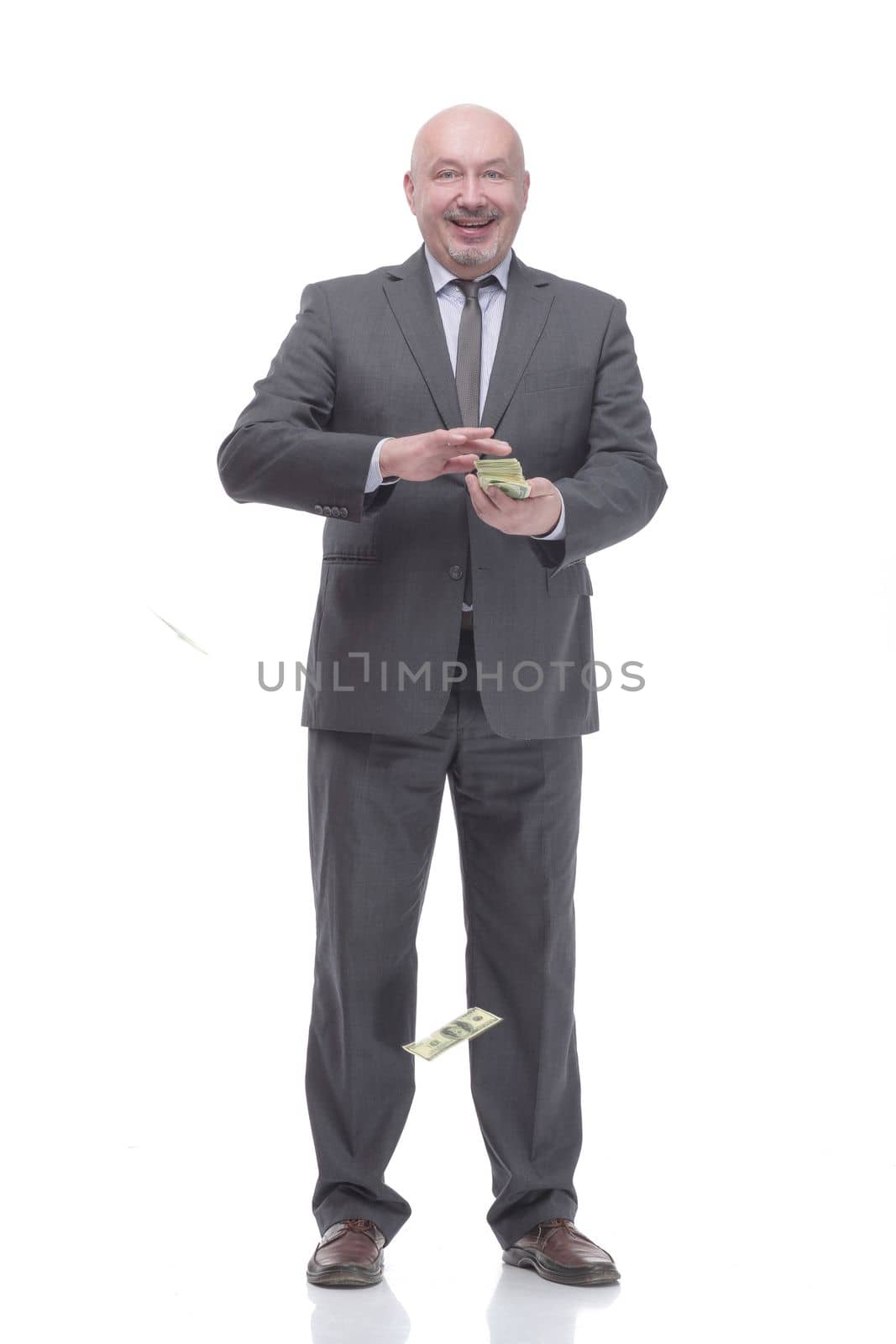in full growth. smiling business man with dollar bills.isolated on a white background.