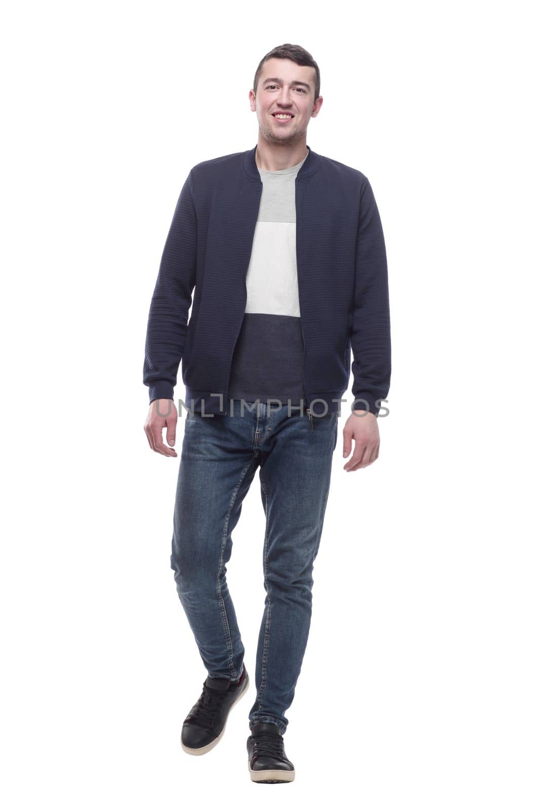 young man in jeans striding forward . isolated on a white by asdf