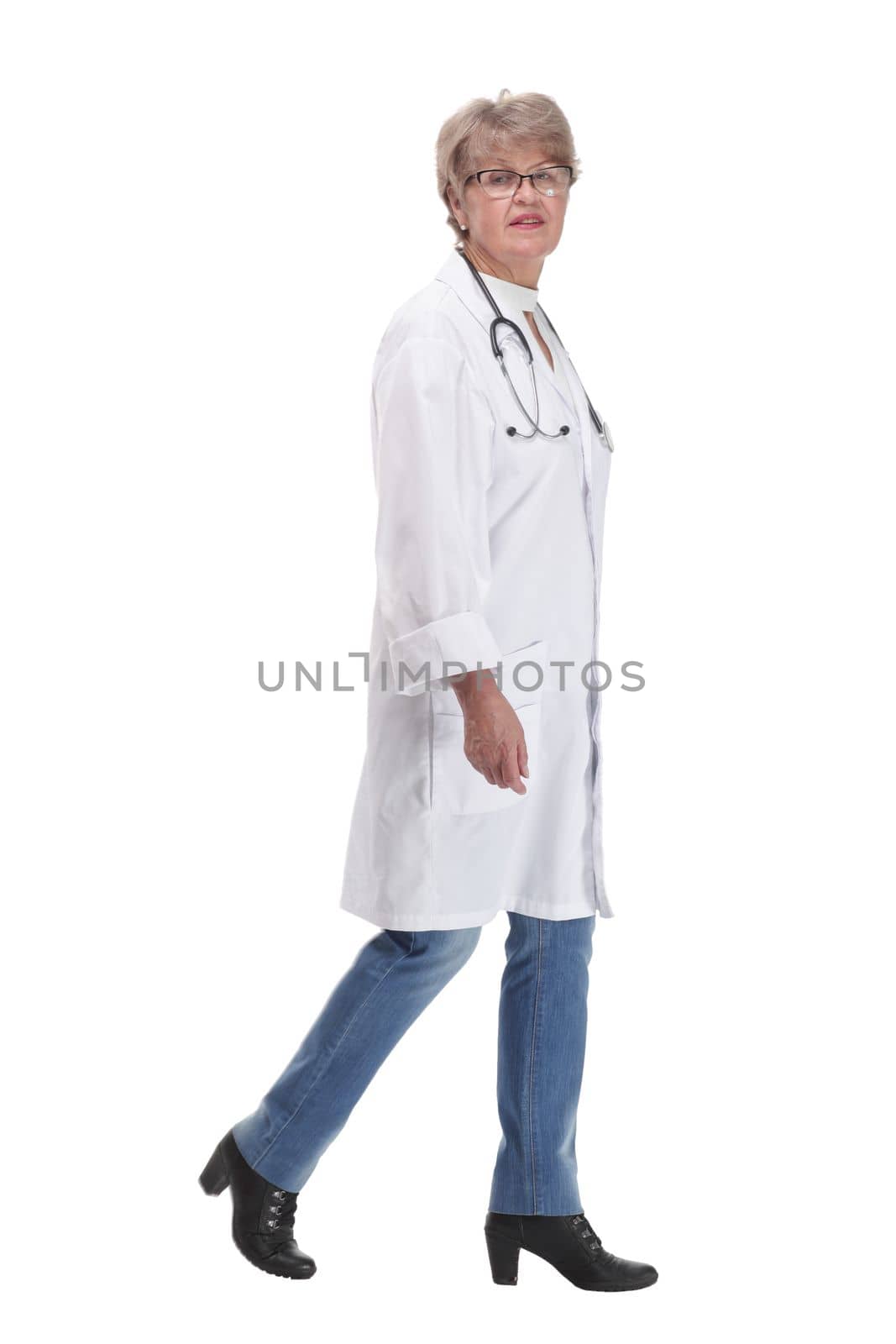 Female doctor walking towards the camera smiling isolated over a white background