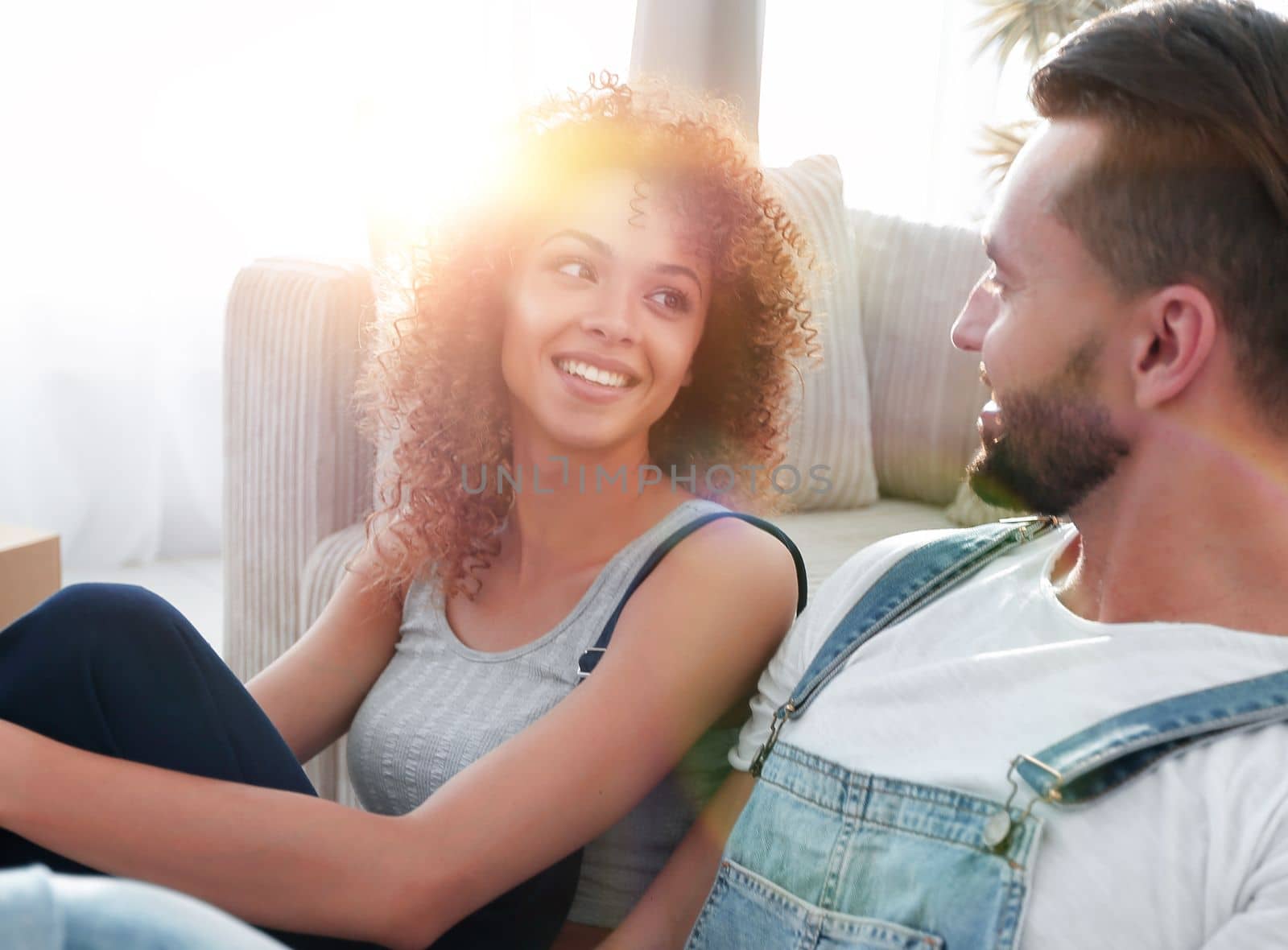 Close-up of a happy married couple sitting in a new apartment by asdf