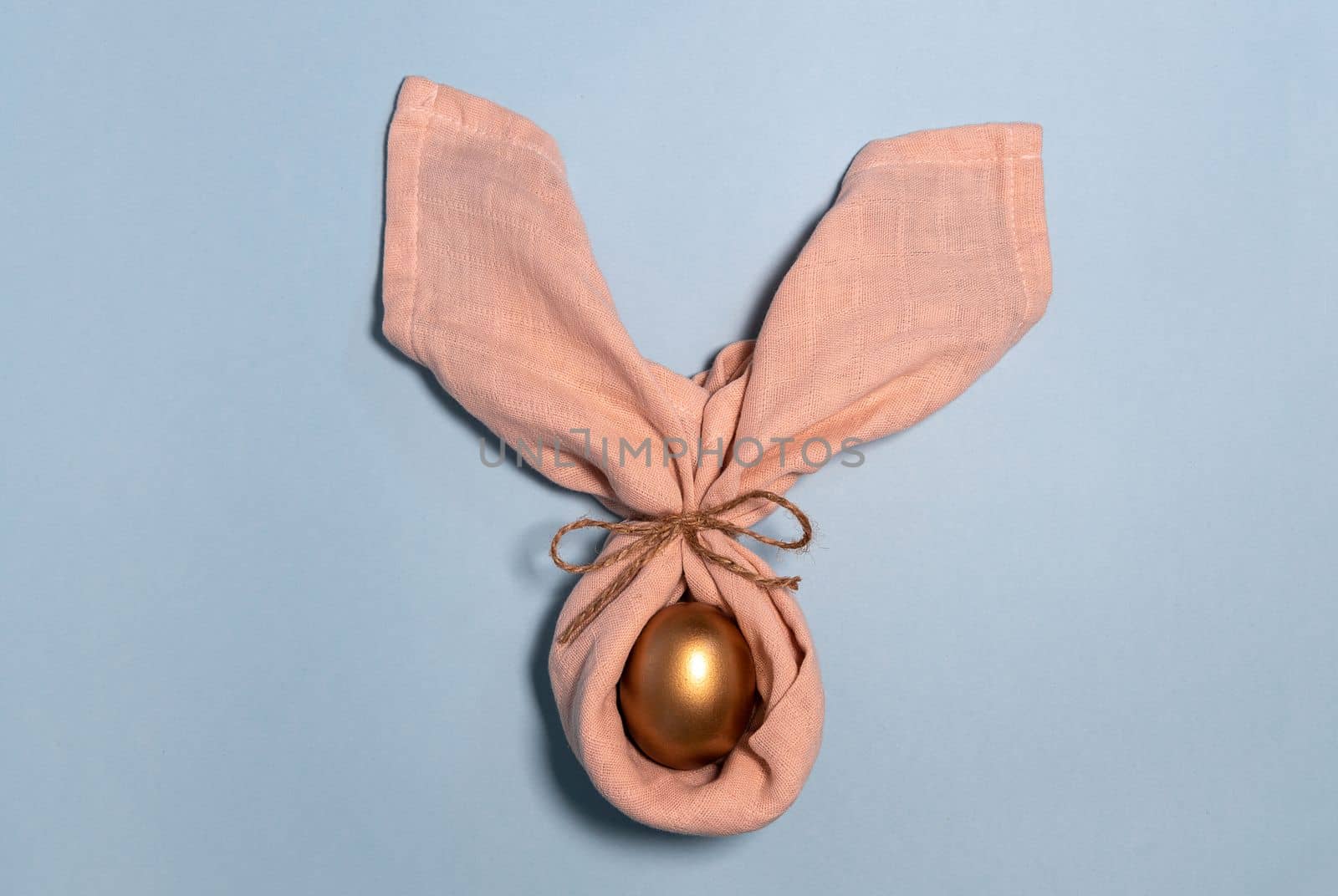 Easter bunny egg. Golden egg decoration as rabbit. Bunny ears. Happy easter concept. Pastel blue background. by Ri6ka