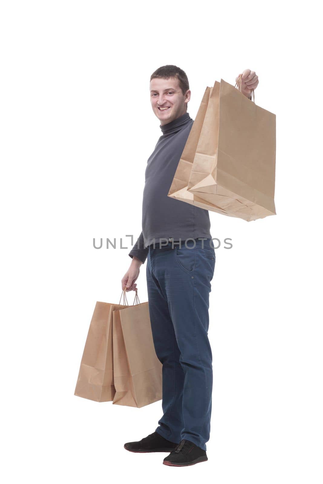 in full growth. casual young man with shopping bags. by asdf