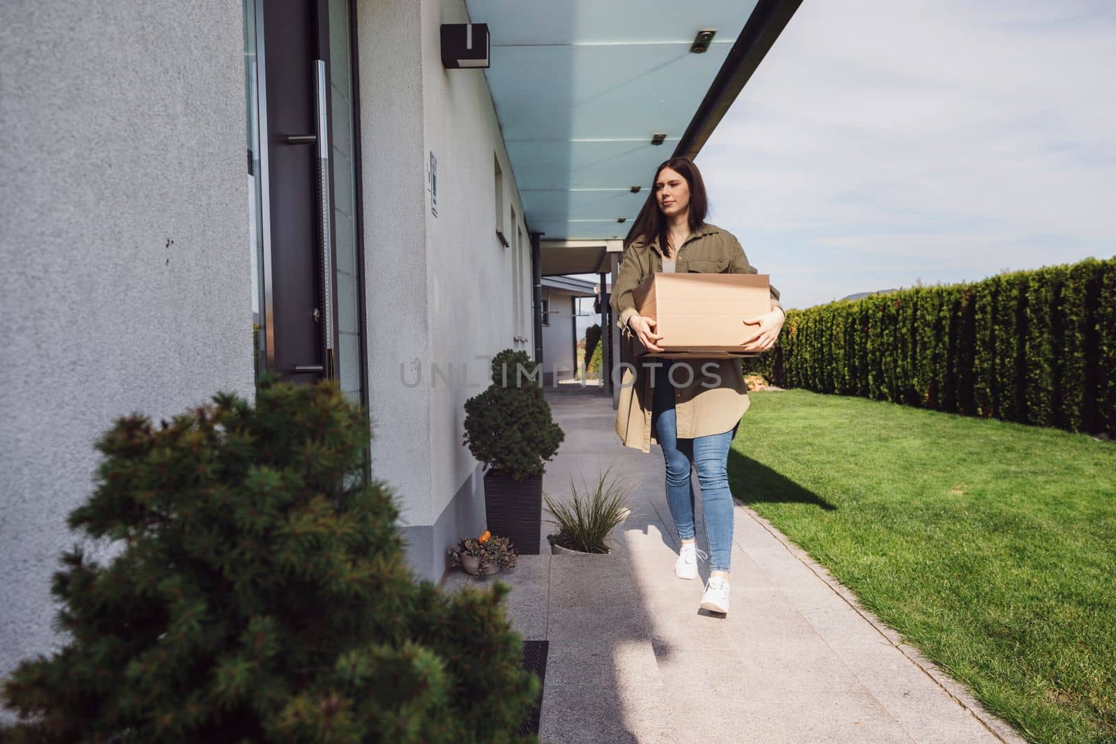 Young caucasian woman receiving a big box of her online orders. Woman opening the package, getting excited to see the stuff she bought. High quality photo