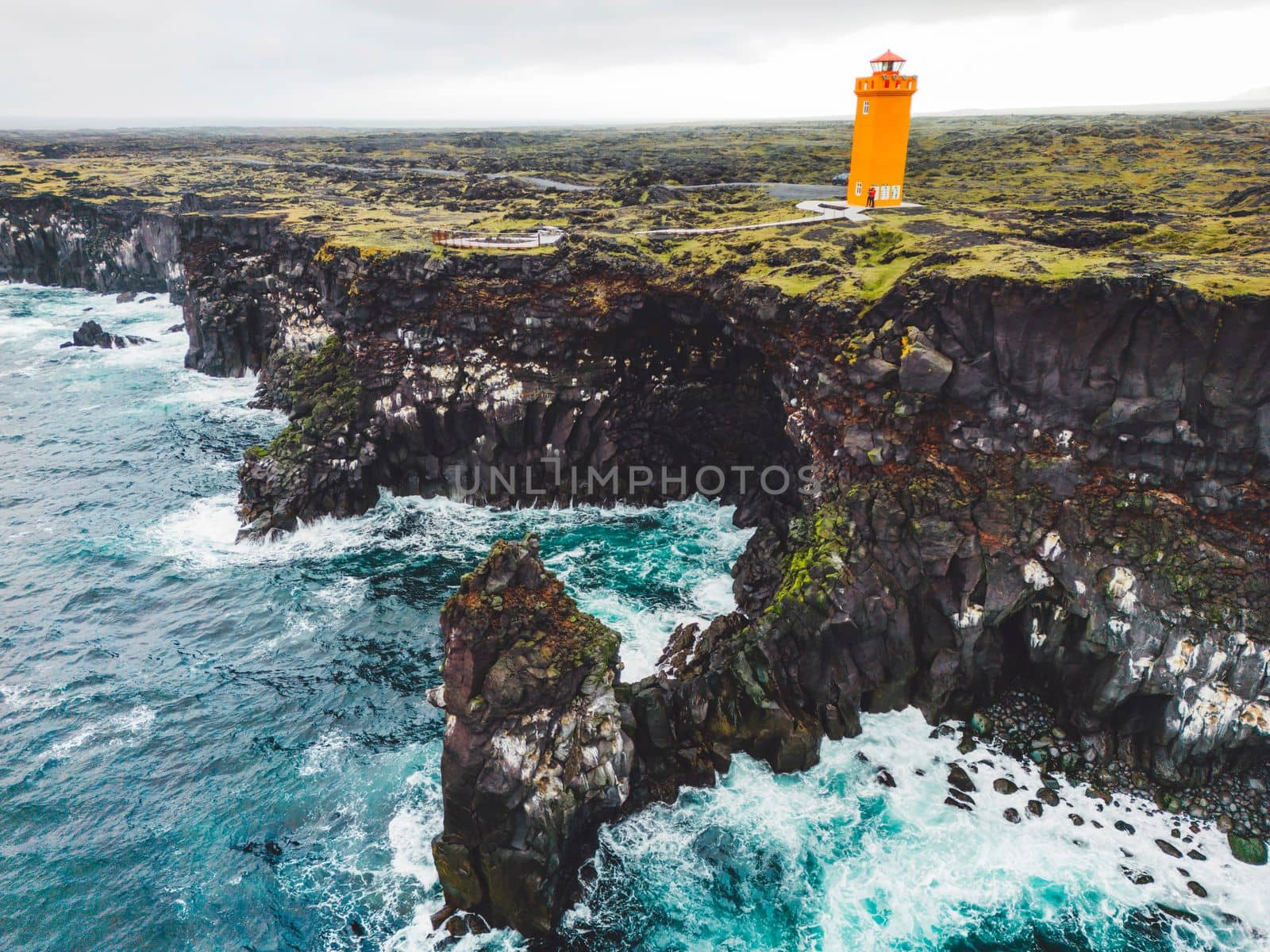 View of orange Svortuloft Lighthouse by the sea in West Iceland highlands, Snaefellsnes peninsula, View Point near Svortuloft Lighthouse. Spectacular black volcanic rocky ocean coast with cave arch and towers. High quality photo