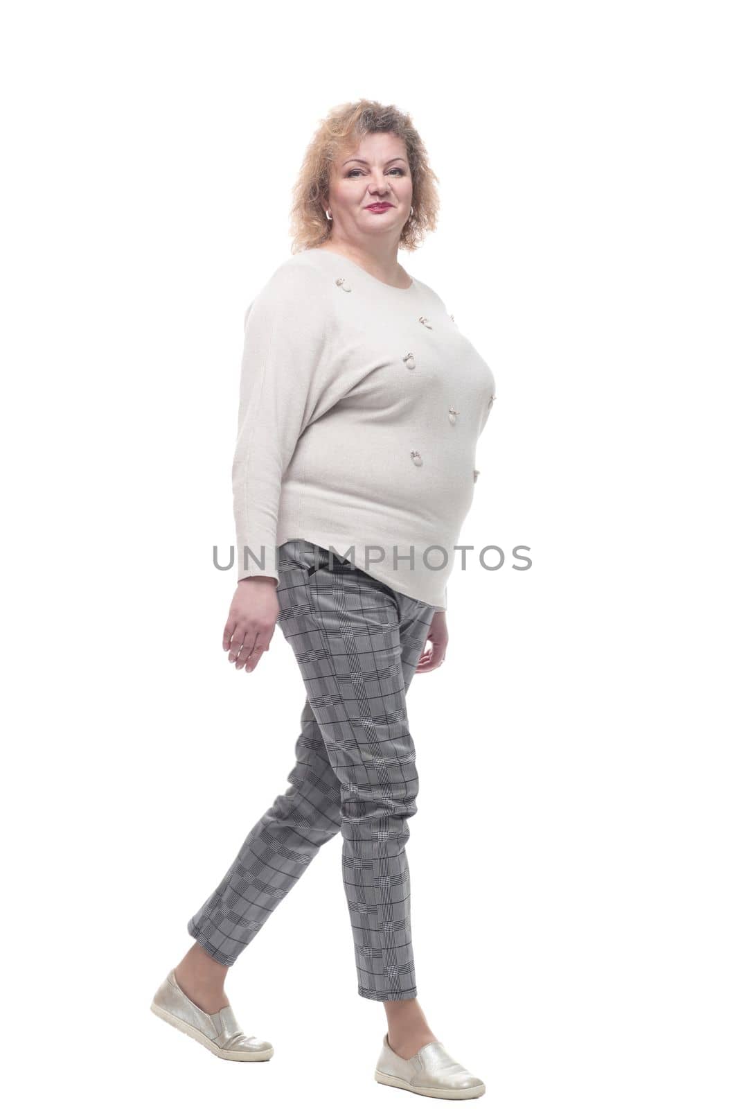 casual woman in a jumper and trousers striding forward. isolated on a white background.