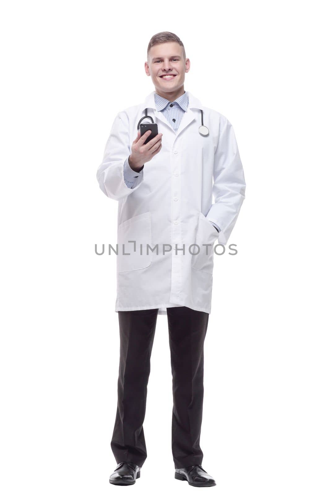 in full growth. young doctor with a smartphone. isolated on a white background.
