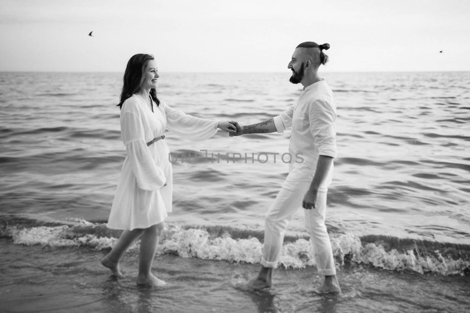 a guy with a girl in white clothes on the seashore by Andreua