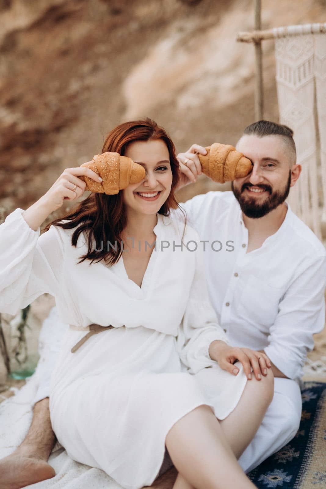 pregnant girl and boyfriend on a picnic by the sea in white clothes