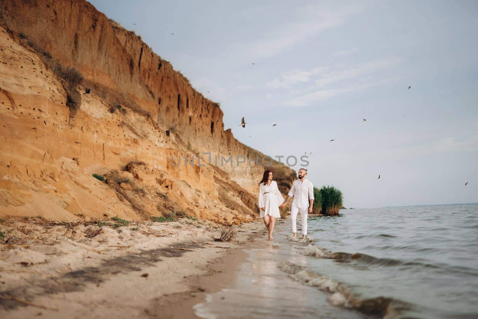 a guy with a girl in white clothes on the seashore by Andreua