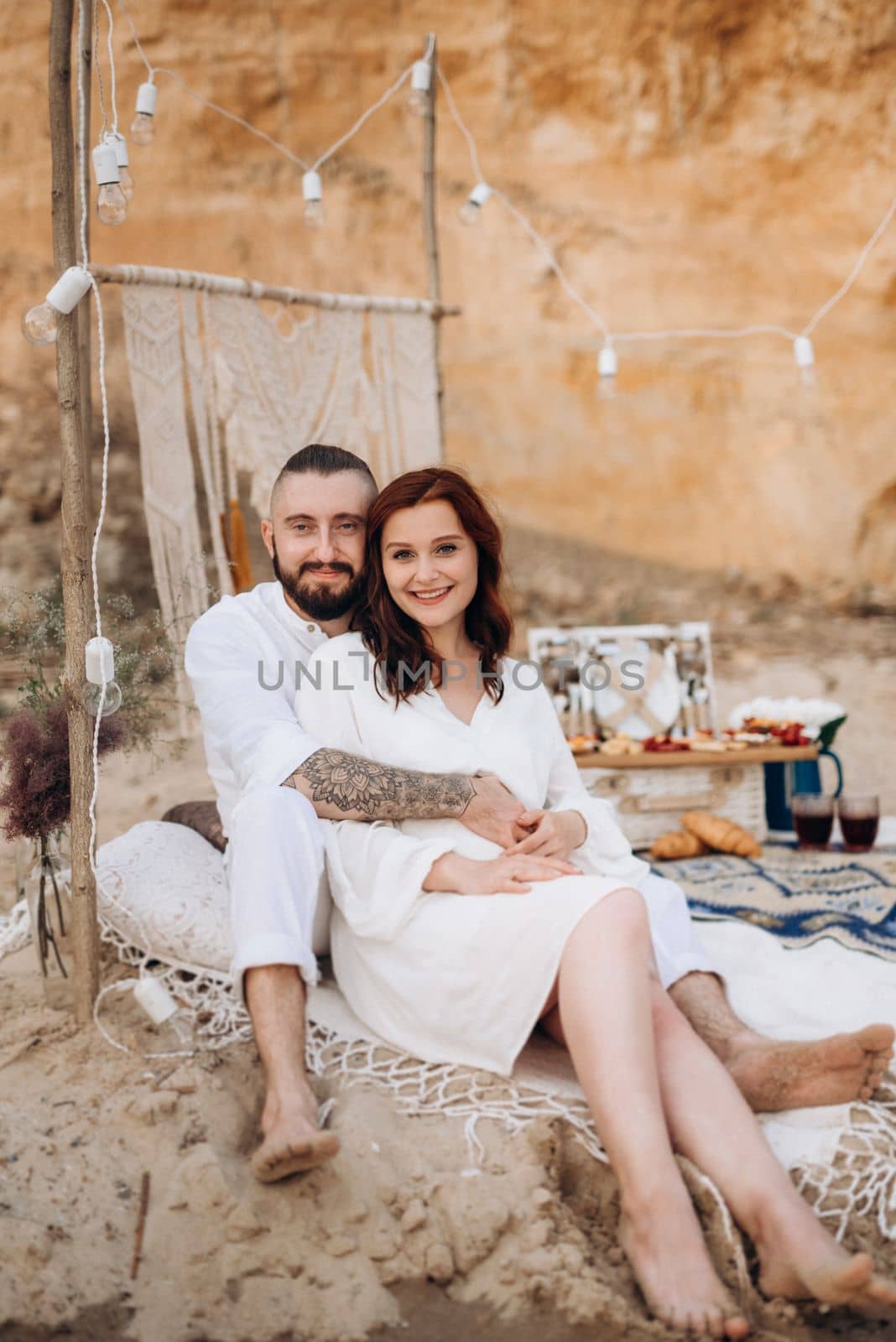 pregnant girl and boyfriend on a picnic by the sea in white clothes