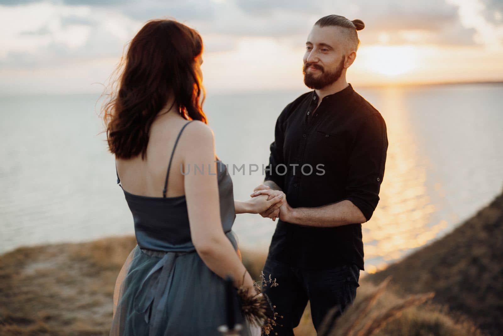 wedding ceremony of a girl and a guy on high hills near the sea