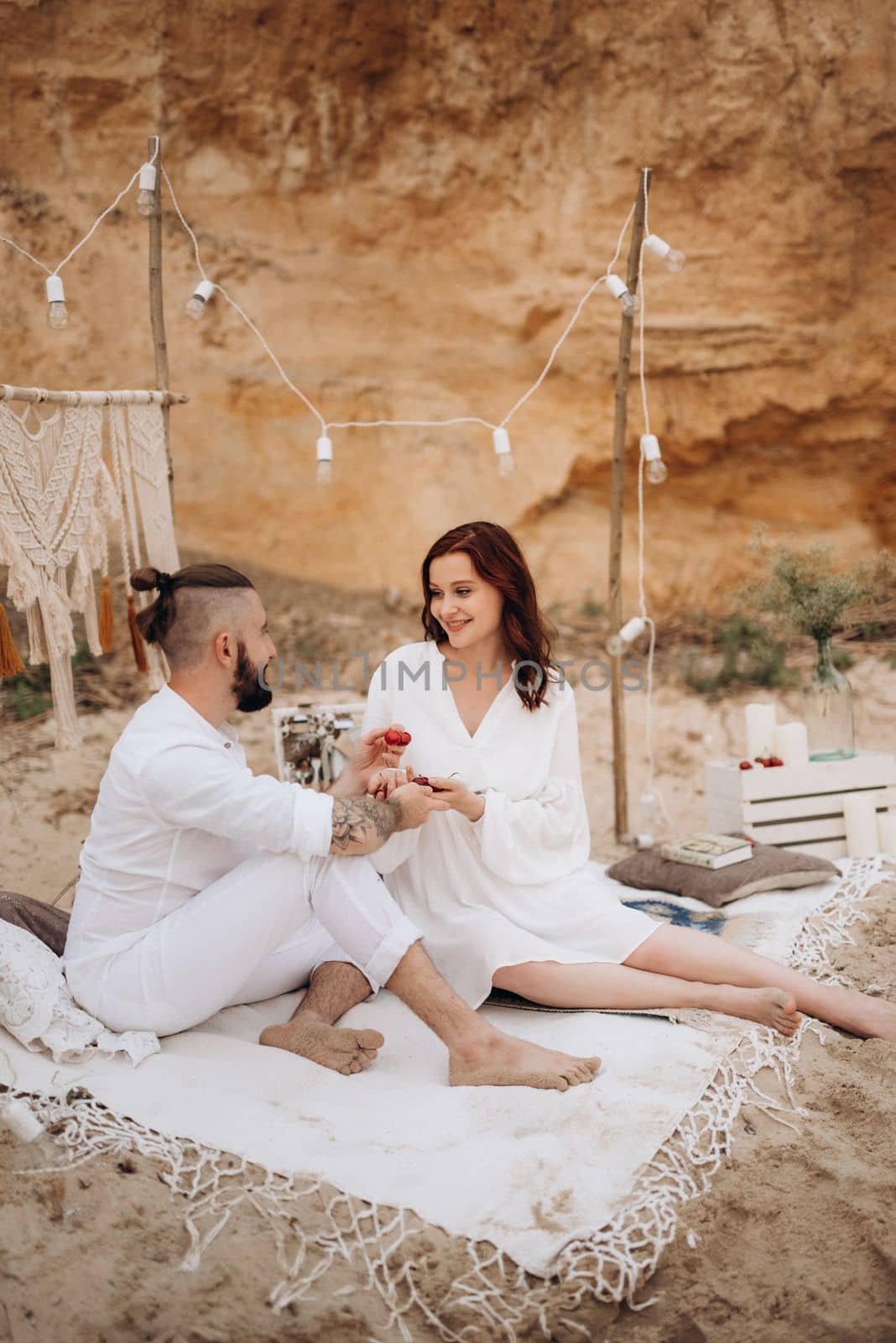 pregnant girl and boyfriend on a picnic by the sea in white clothes