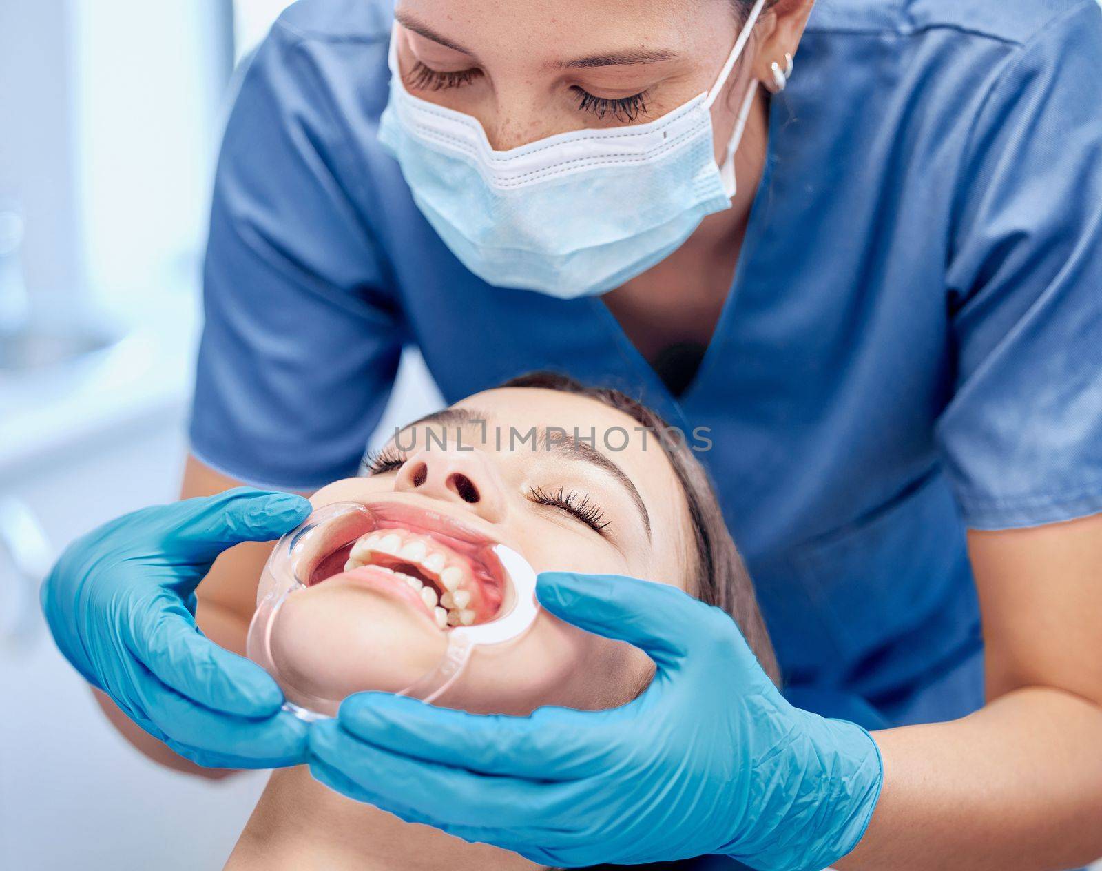 This feels so uncomfortable. a young dental assistant checking her patients mouth