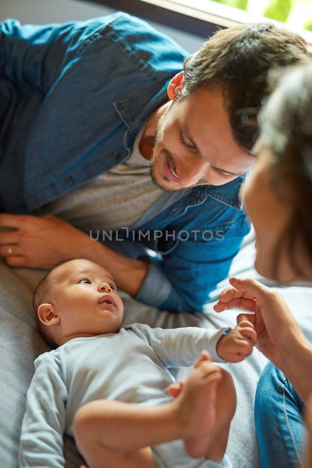 Hes brought nothing but joy and happiness into our lives. a beautiful young couple playing with their infant baby boy at home. by YuriArcurs