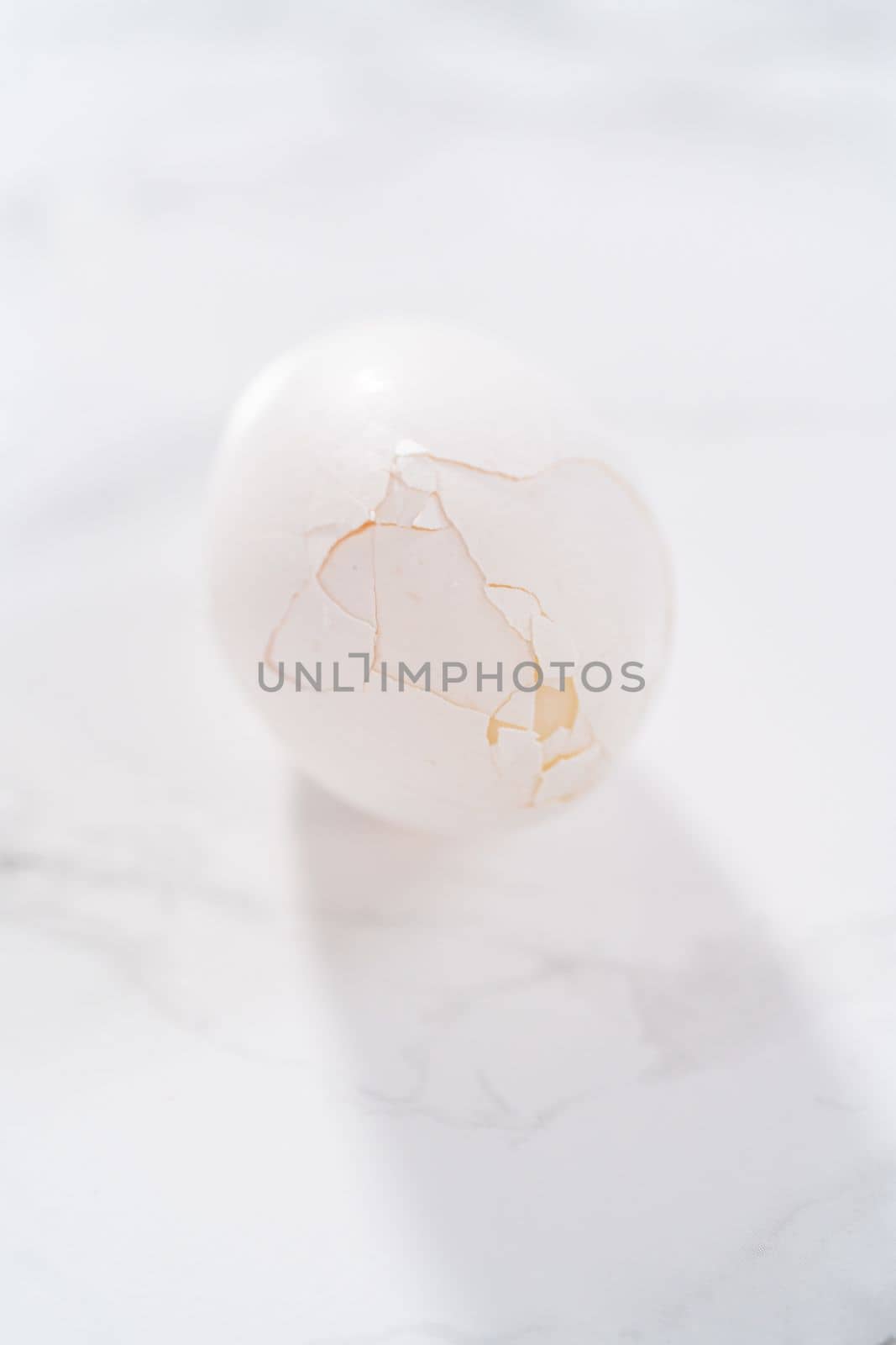 Peeling hard-boiled eggs at the marble kitchen counter.