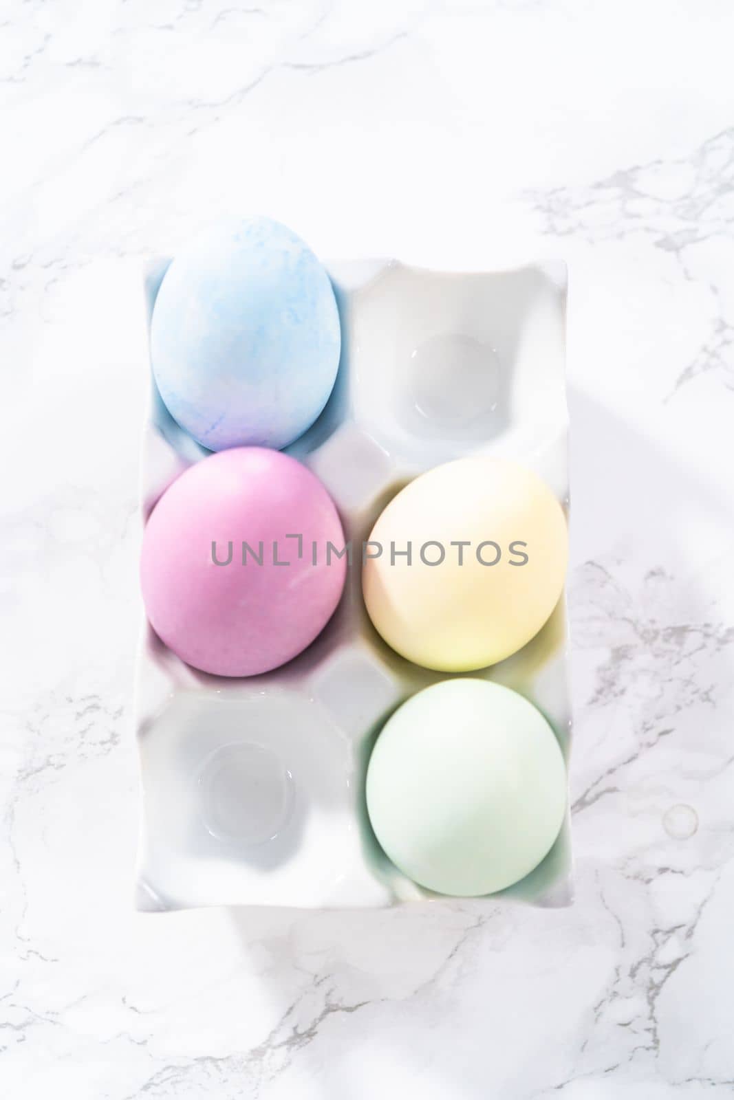 Colored hard-boiled eggs on a marble background.