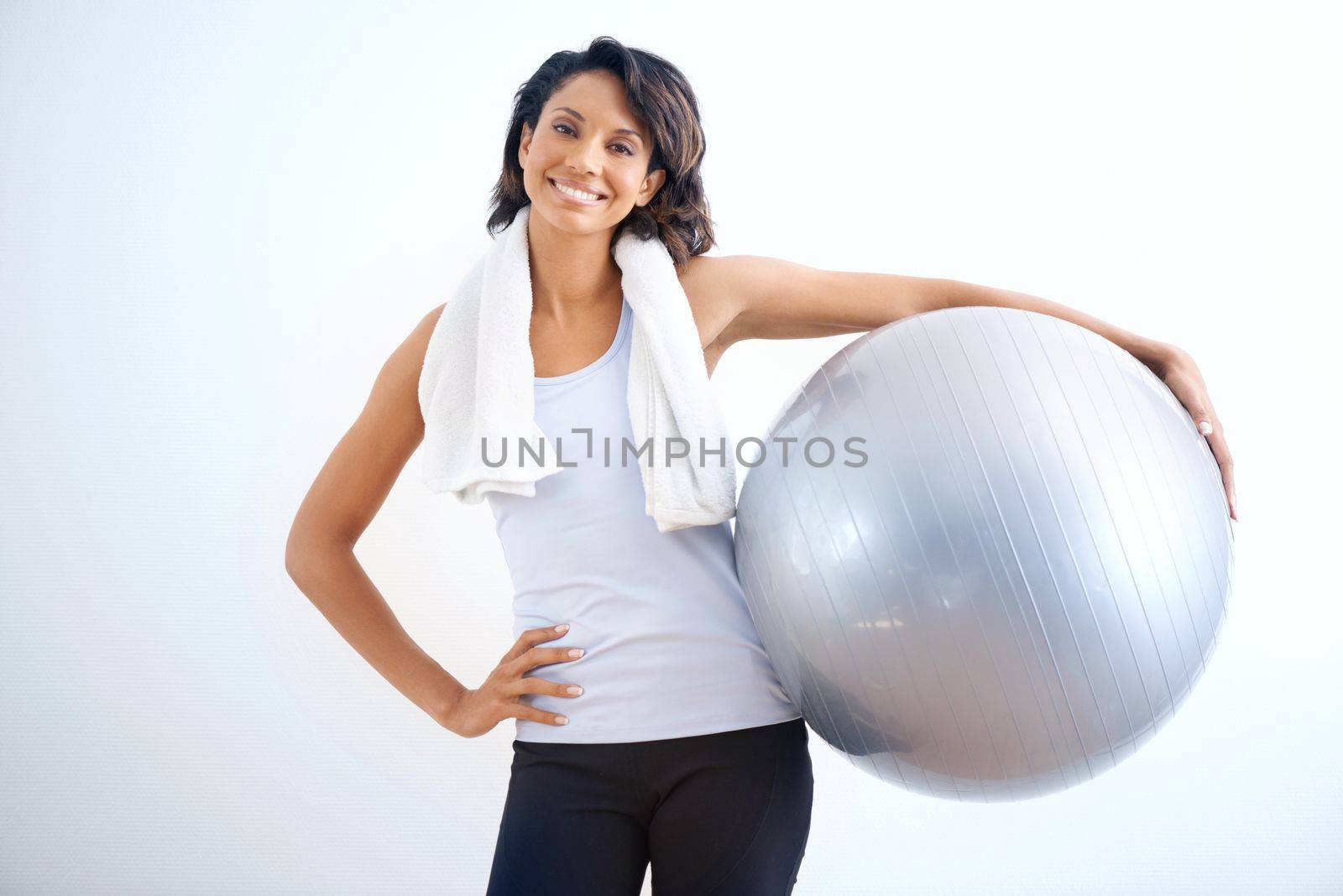 Fitness is my passion. A fit young beauty with a towel wrapped around her neck holding a medicine ball. by YuriArcurs