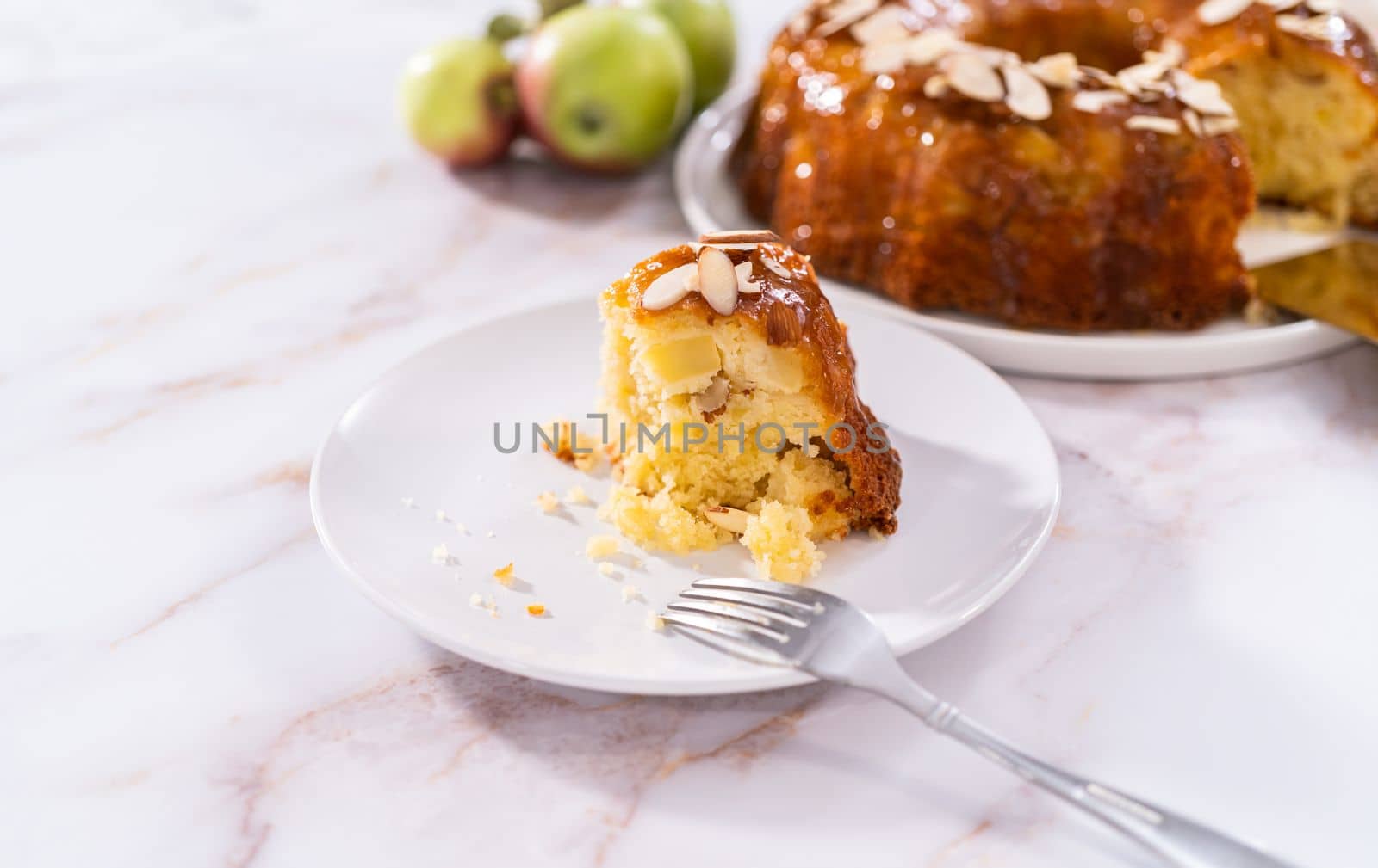 Slice of homemade apple bundt cake with caramel glaze on a plate.