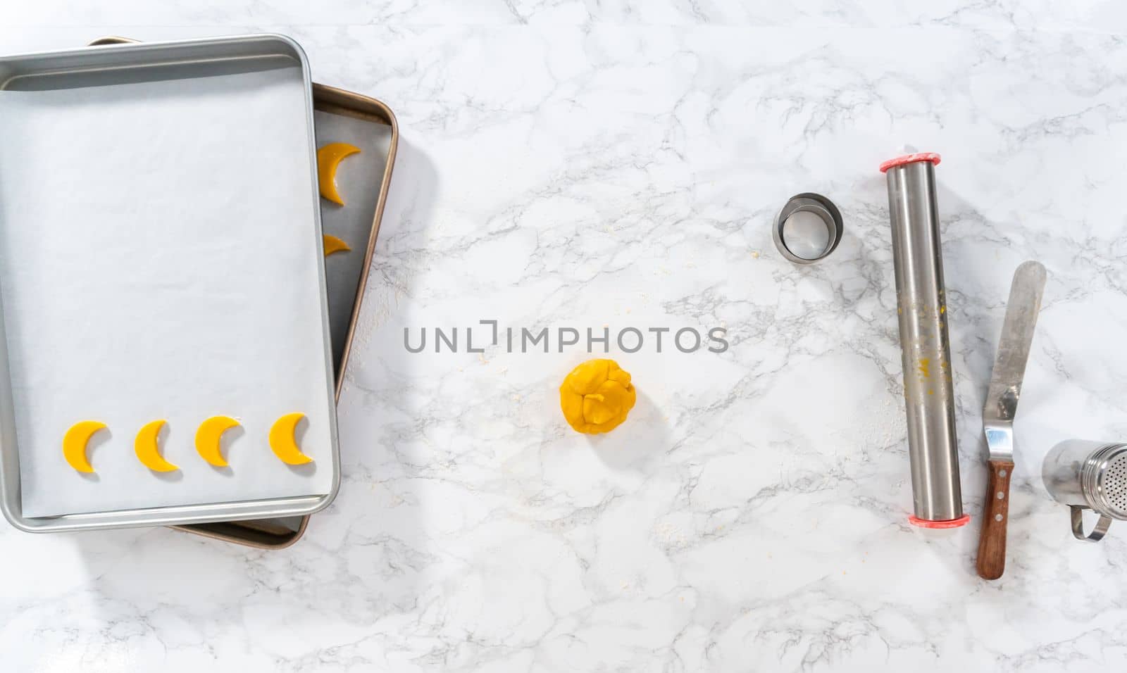 Flat lay. Lemon wedge cookies with lemon glaze. Rolling cookie dough with an adjustable rolling pin and cutting out cookies with cookie cutters to bake lemon wedge cookies with lemon glaze.