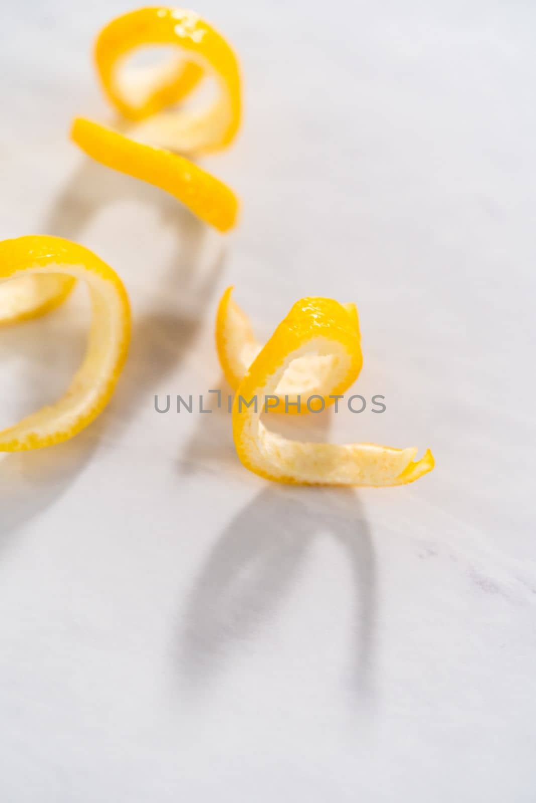 Preparing lemon swirls from the organic lemon to decorate the cocktail.
