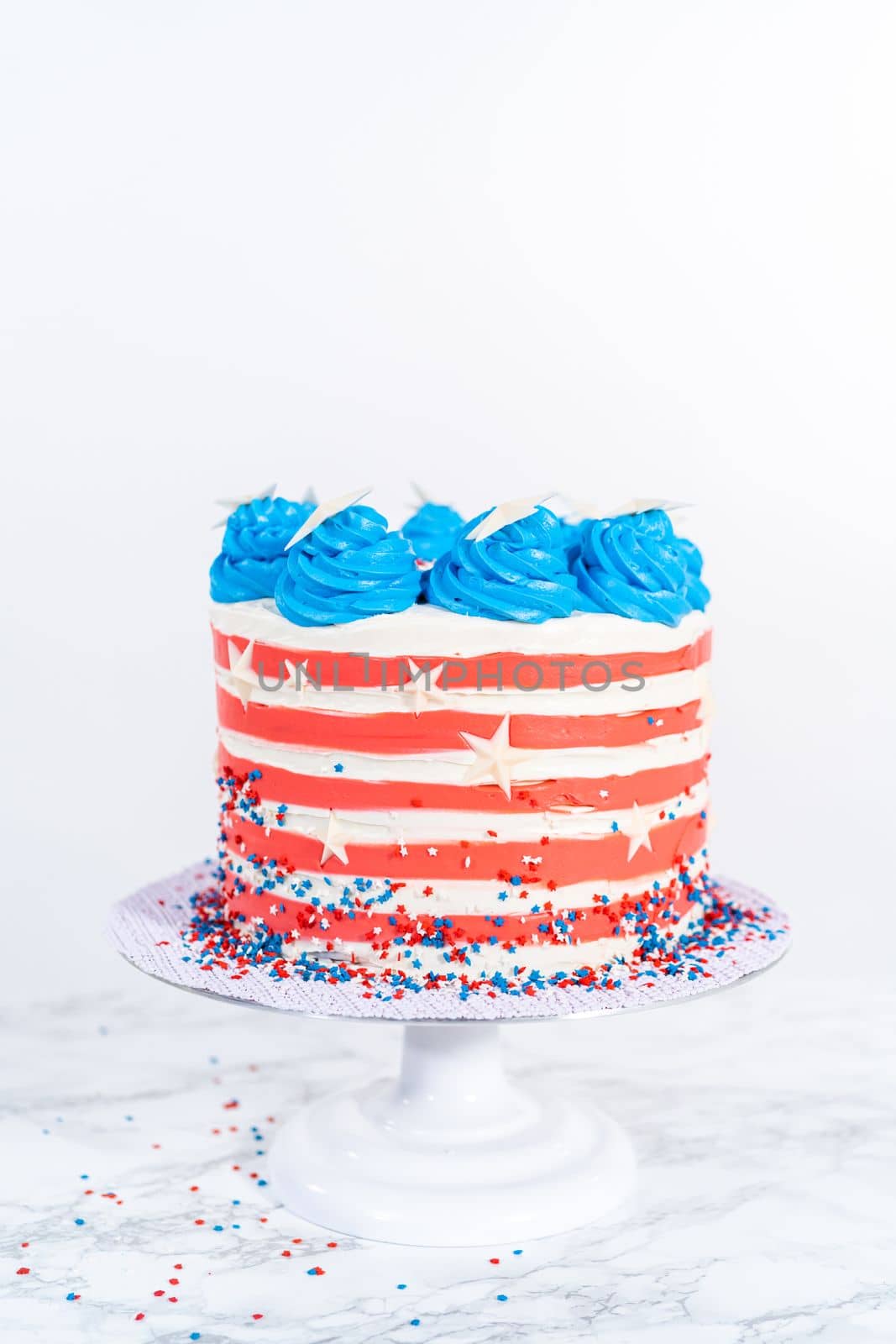 Decorating chocolate cake with white, red, and blue buttercream frosting for July 4th celebration.