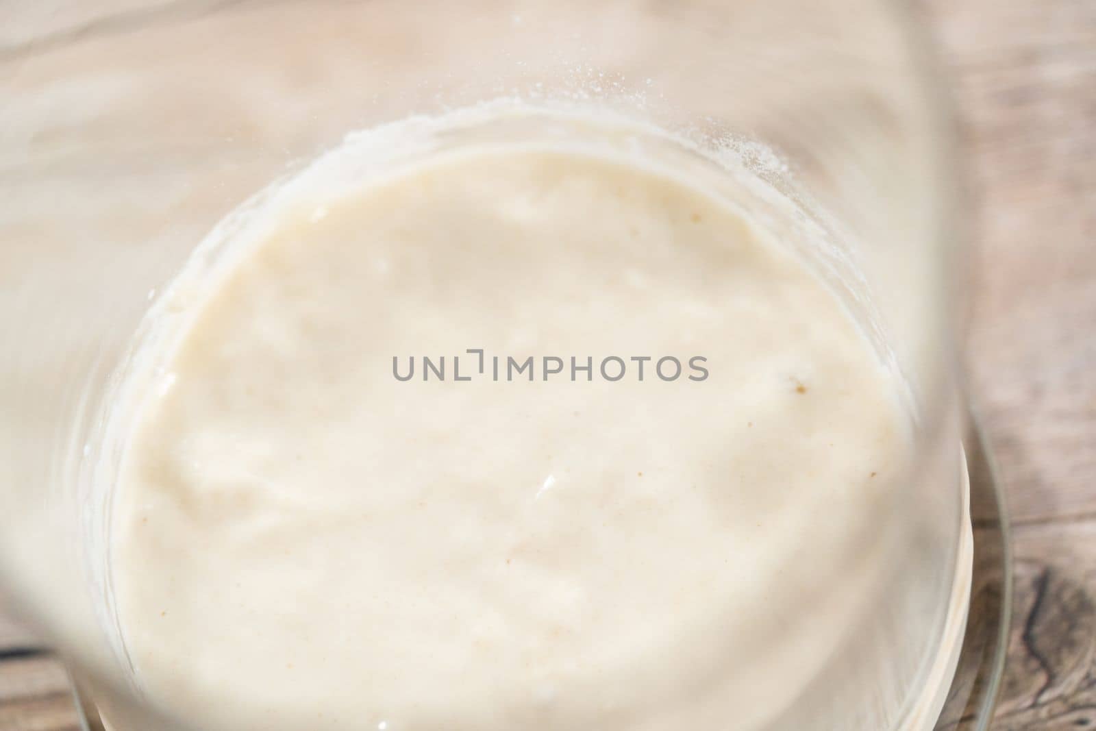 Feeding sourdough starter in a glass mason jar for baking artisan bread.