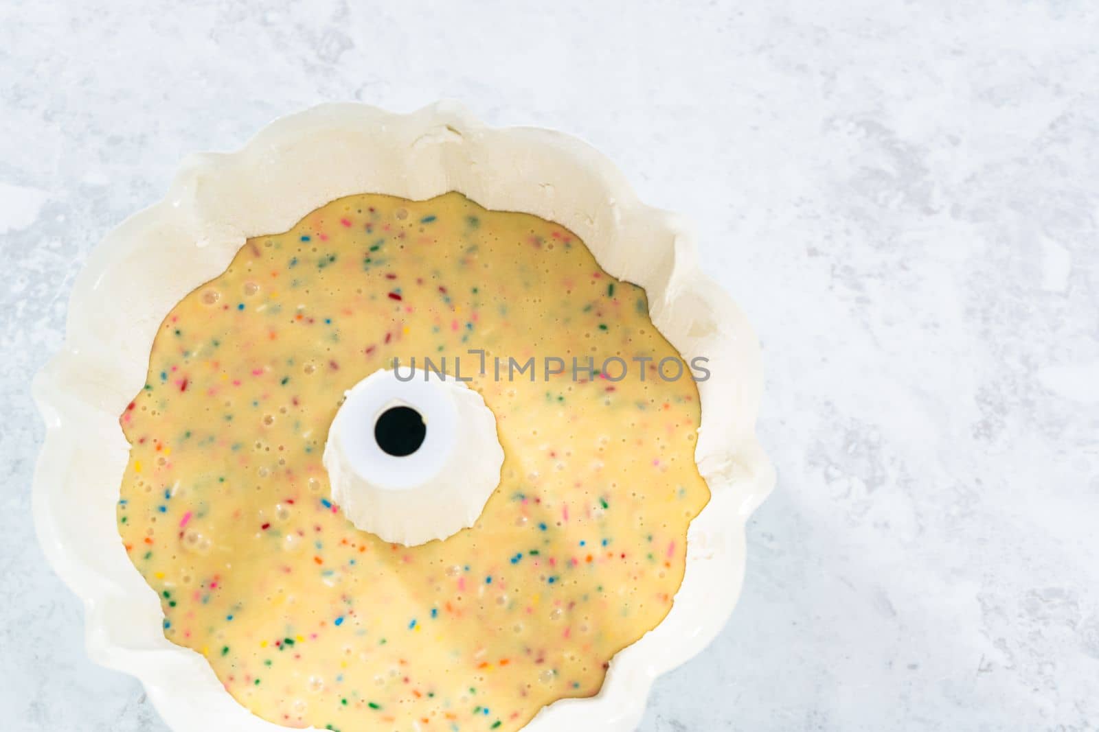 Cake batter in a bundt cake pan to bake funfettti bundt cake.