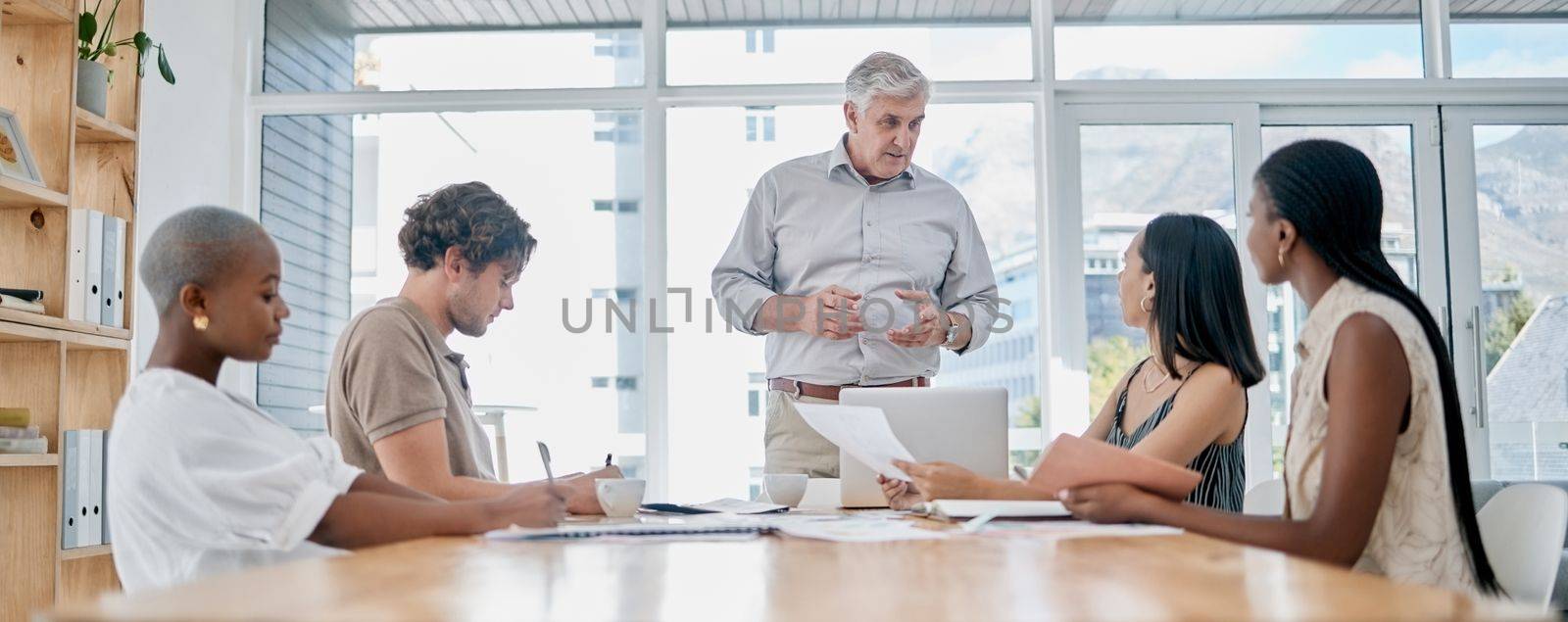 Meeting, coaching and education with a business man manager and his team in the boardroom for planning or strategy. Leadership, management or teamwork with a senior male leader and employee group by YuriArcurs