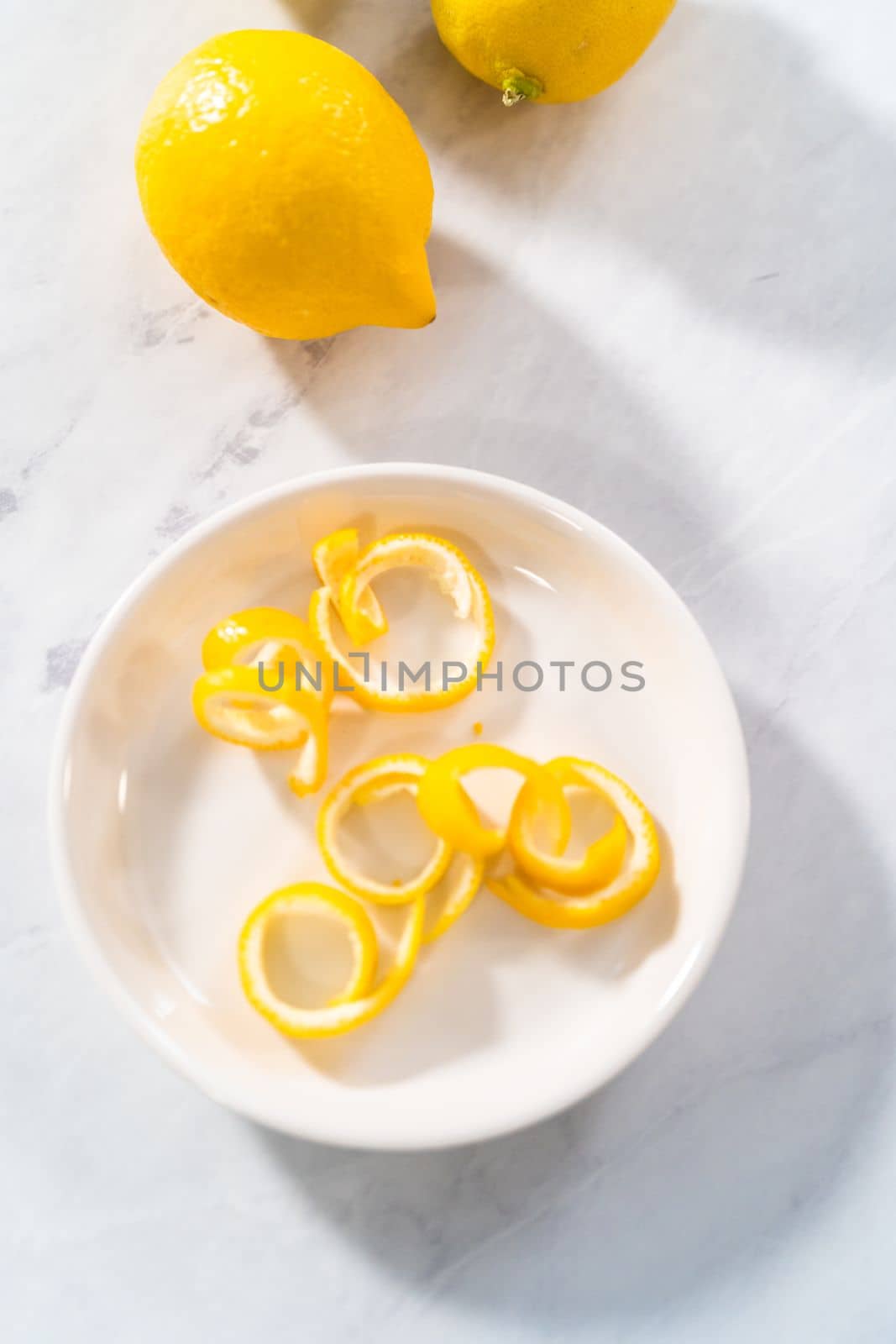 Preparing lemon swirls from the organic lemon to decorate the cocktail.