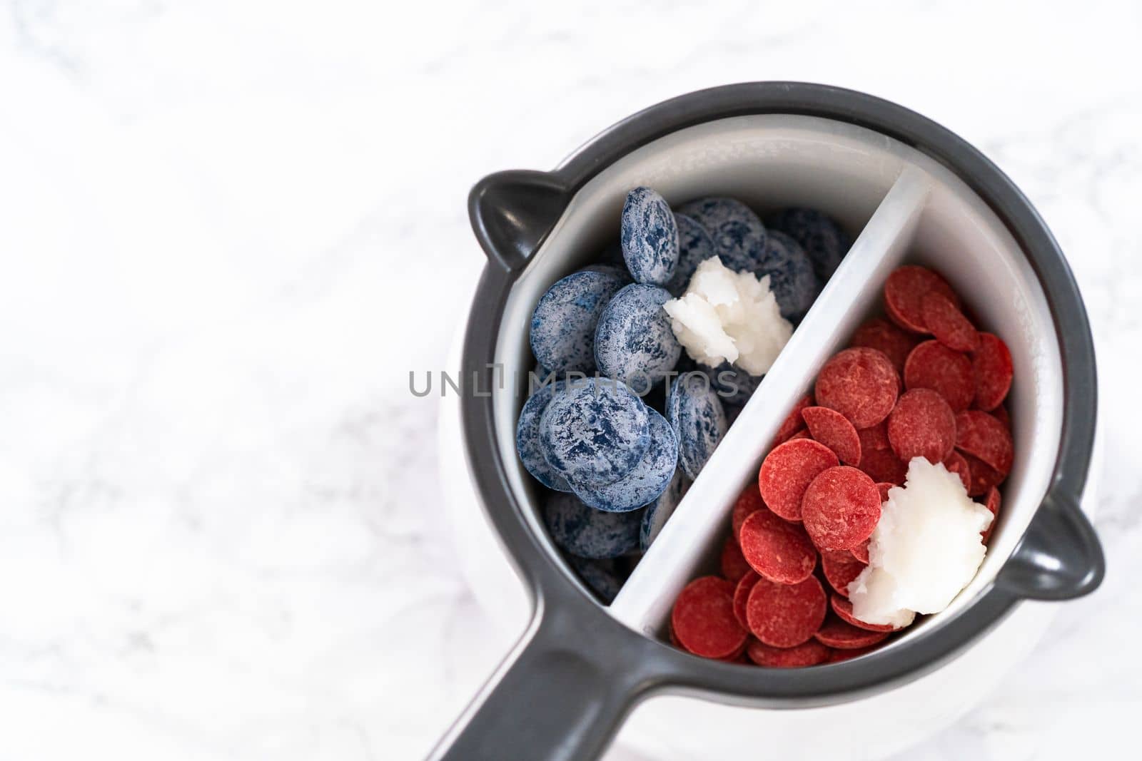 Melting chocolate chips in a candy melting pot to make red, white, and blue chocolate-covered pretzel twists.