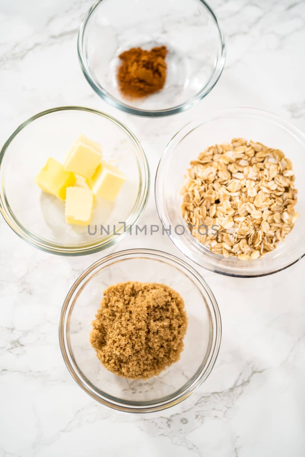 Measured ingredients in glass mixing bowls to bake banana oatmeal muffins.