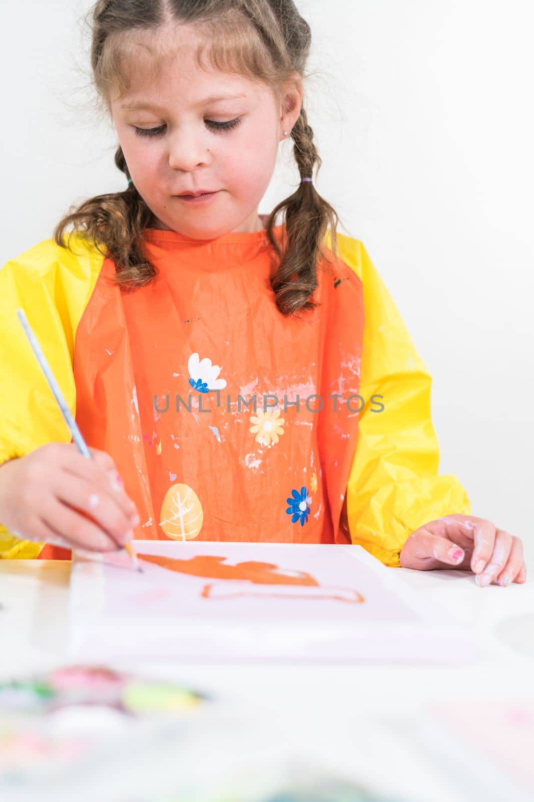 Little girl working on an art project with acrylic paint at homeschool.